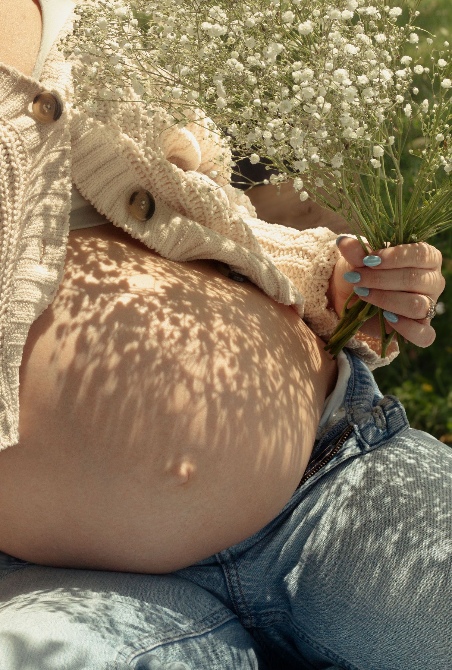 Close-up mother's pregnant belly during a candid maternity photography session in Fayetteville, NC.