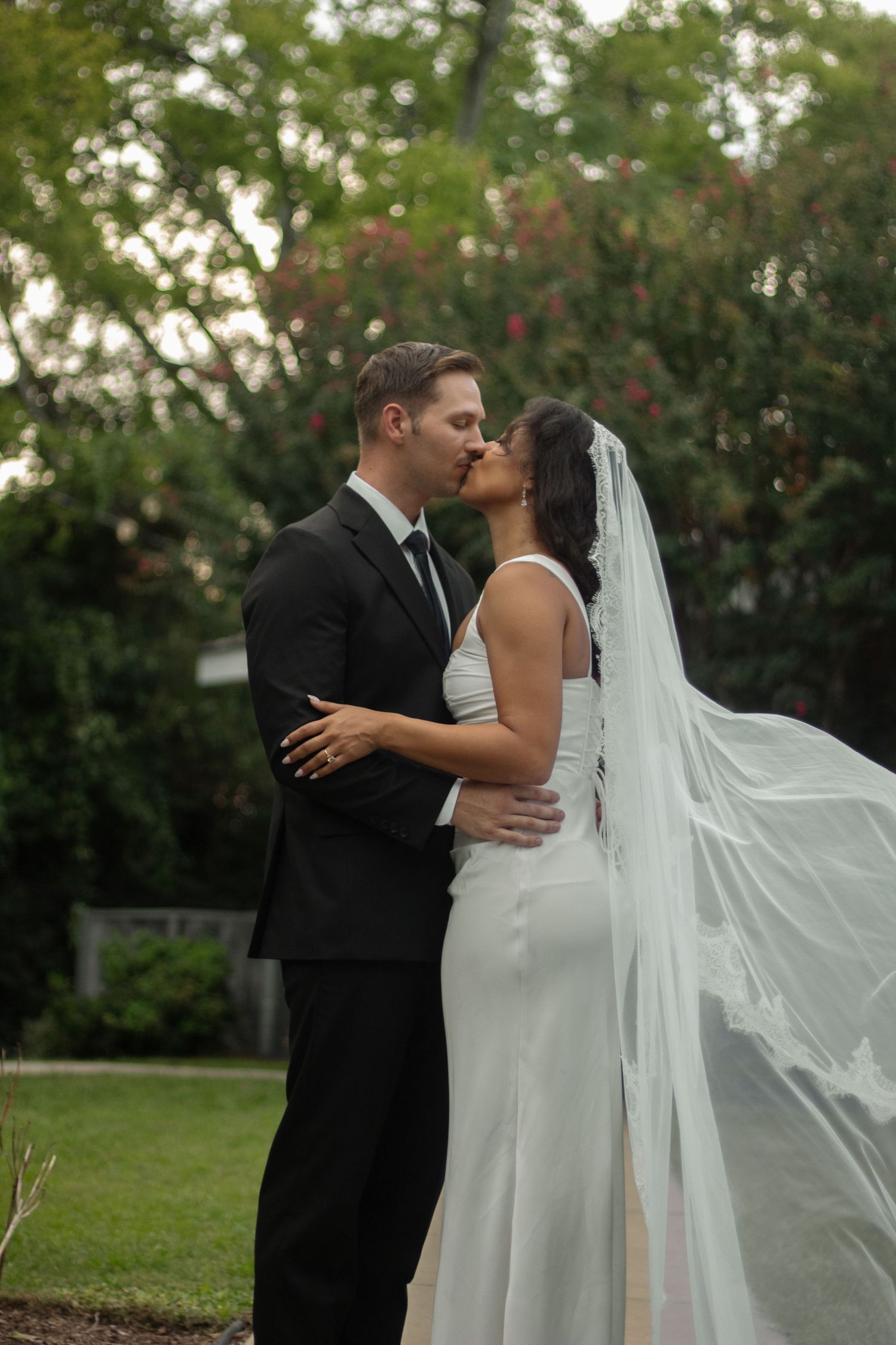 Bride and groom portraits with veil blowing in wind after their small church wedding in Fayetteville, NC.