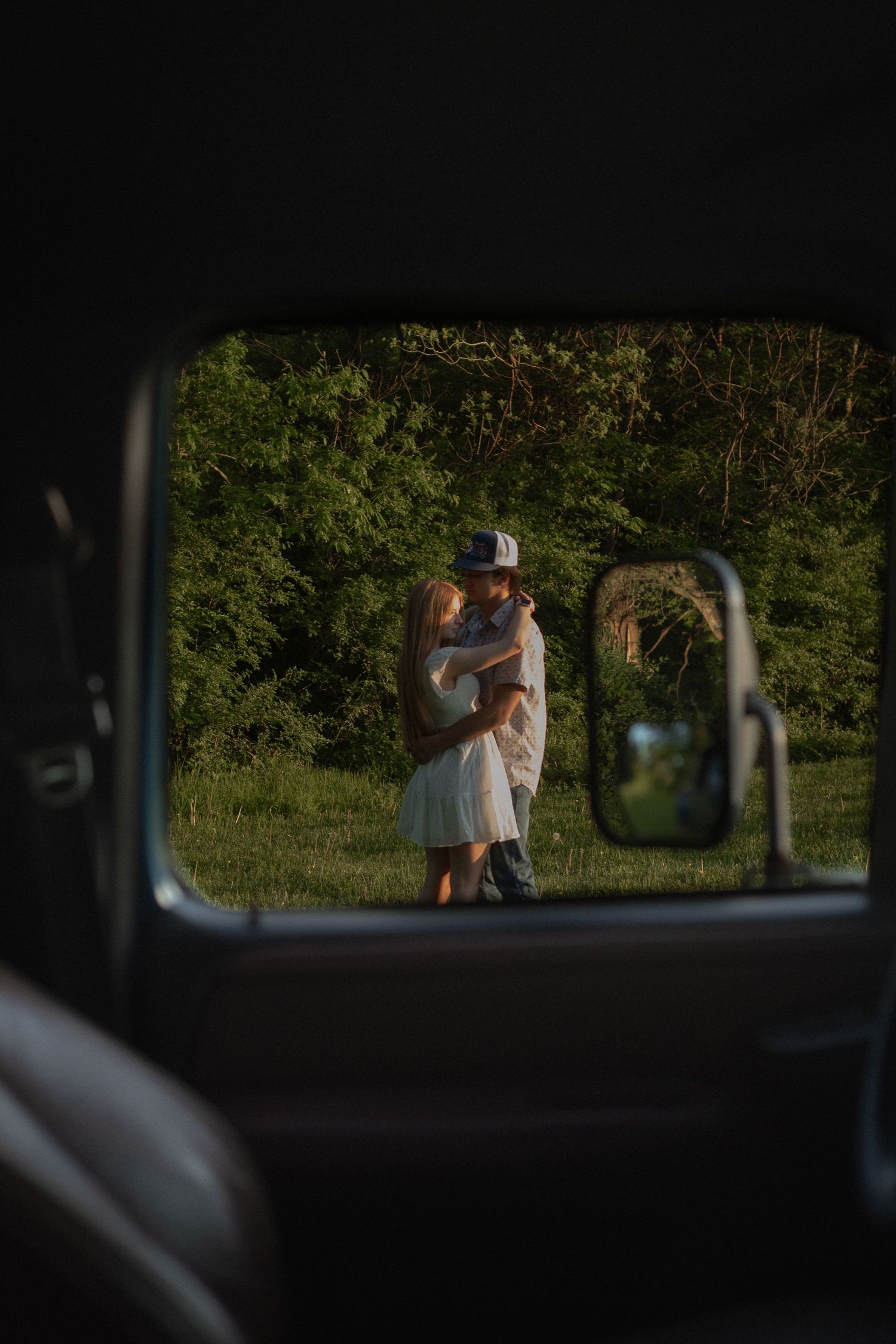 Picture through truck window of couple dancing during a candid couples photography session in Orange, CT.