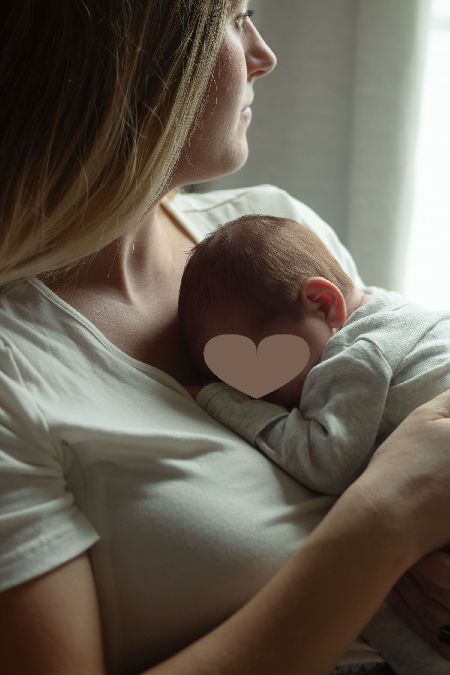 Mother holding newborn baby in arms in nursery during a newborn photography session in Fayetteville, NC.