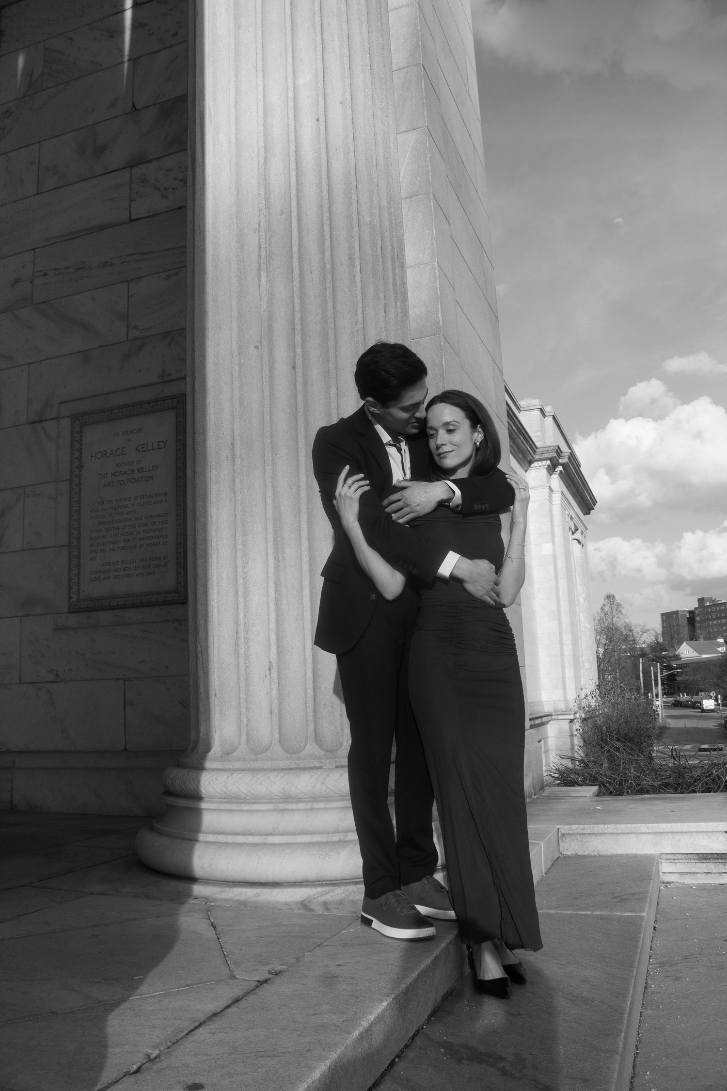Couple embracing on the steps of the Cleveland Museum of Art during an engagement session in Cleveland, Ohio.
