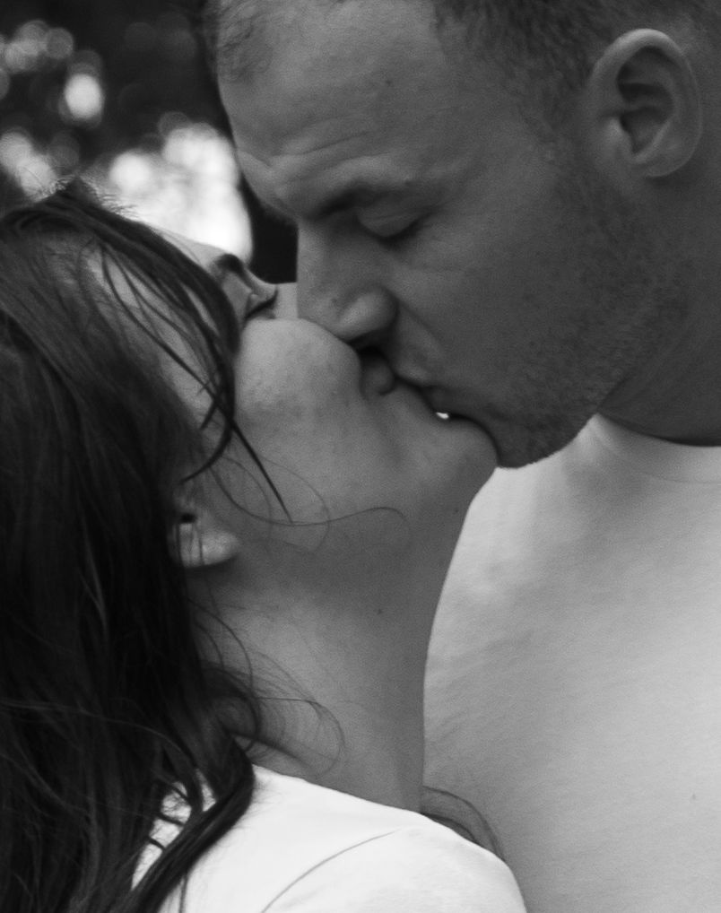 Parents kissing during an outdoor family photo session in Raeford, NC.