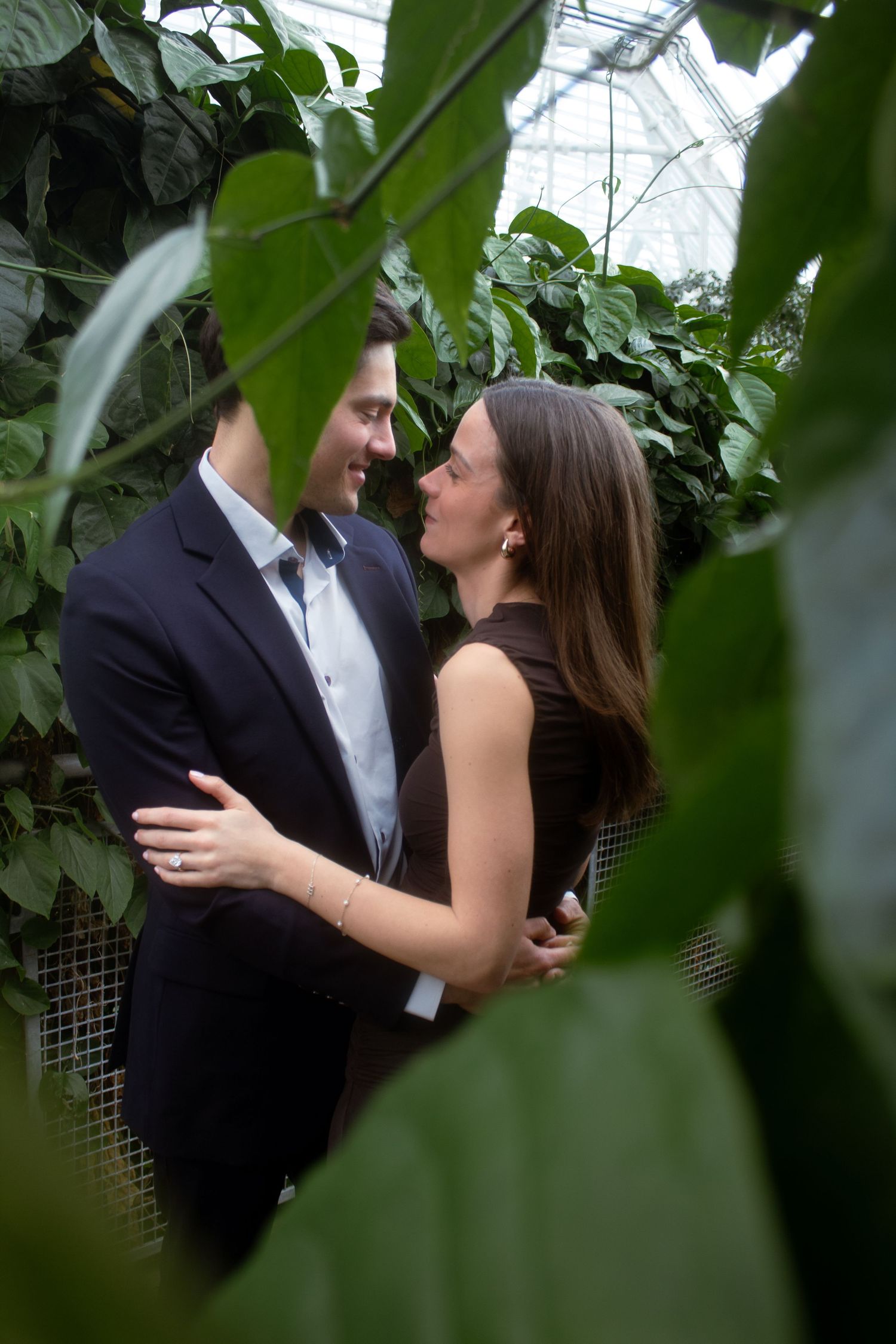 Couple smiling at each other among the plants at Cleveland Botanical Garden during their engagement photography session.