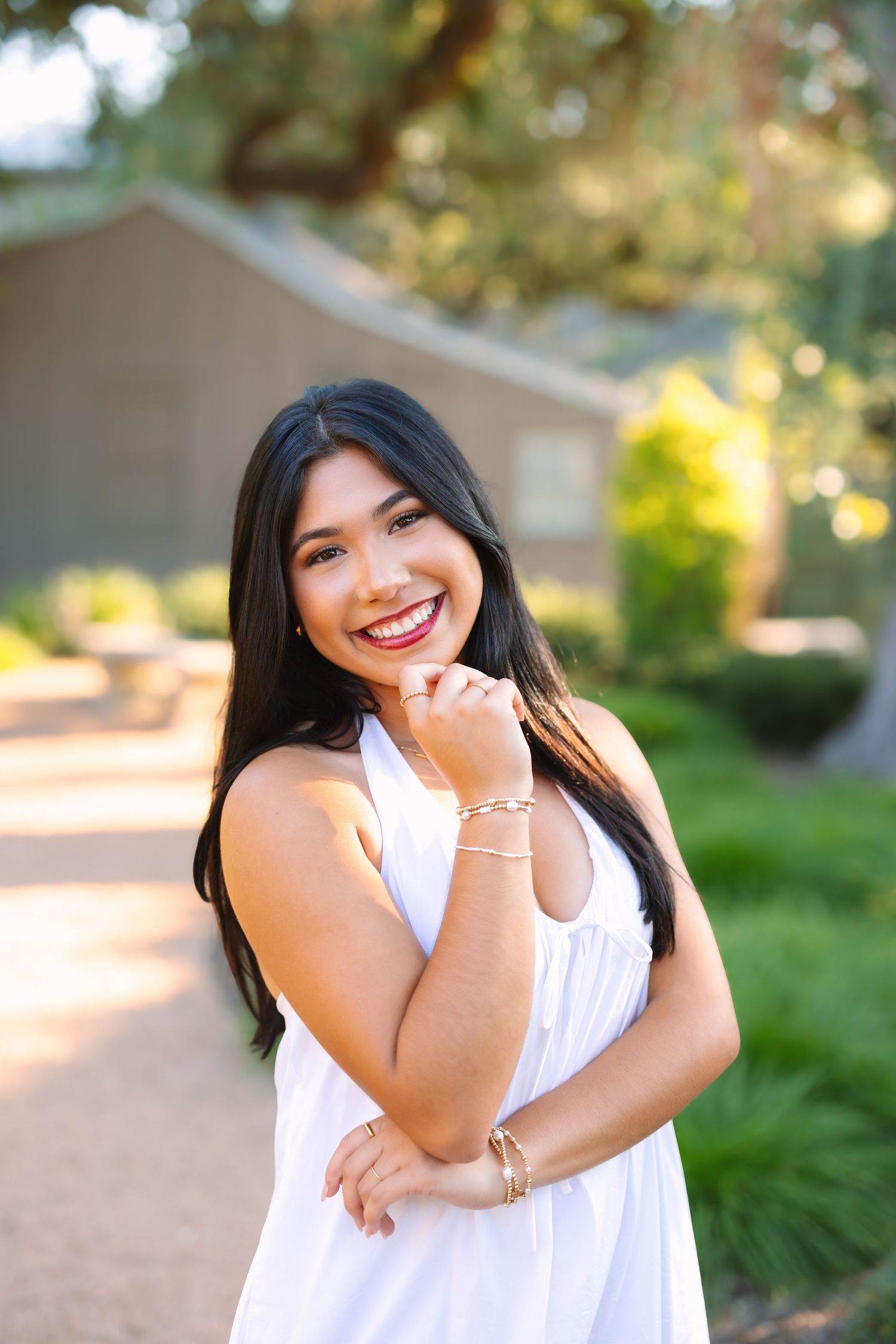 A casual white summer dress is modeled against a natural outdoor background.
