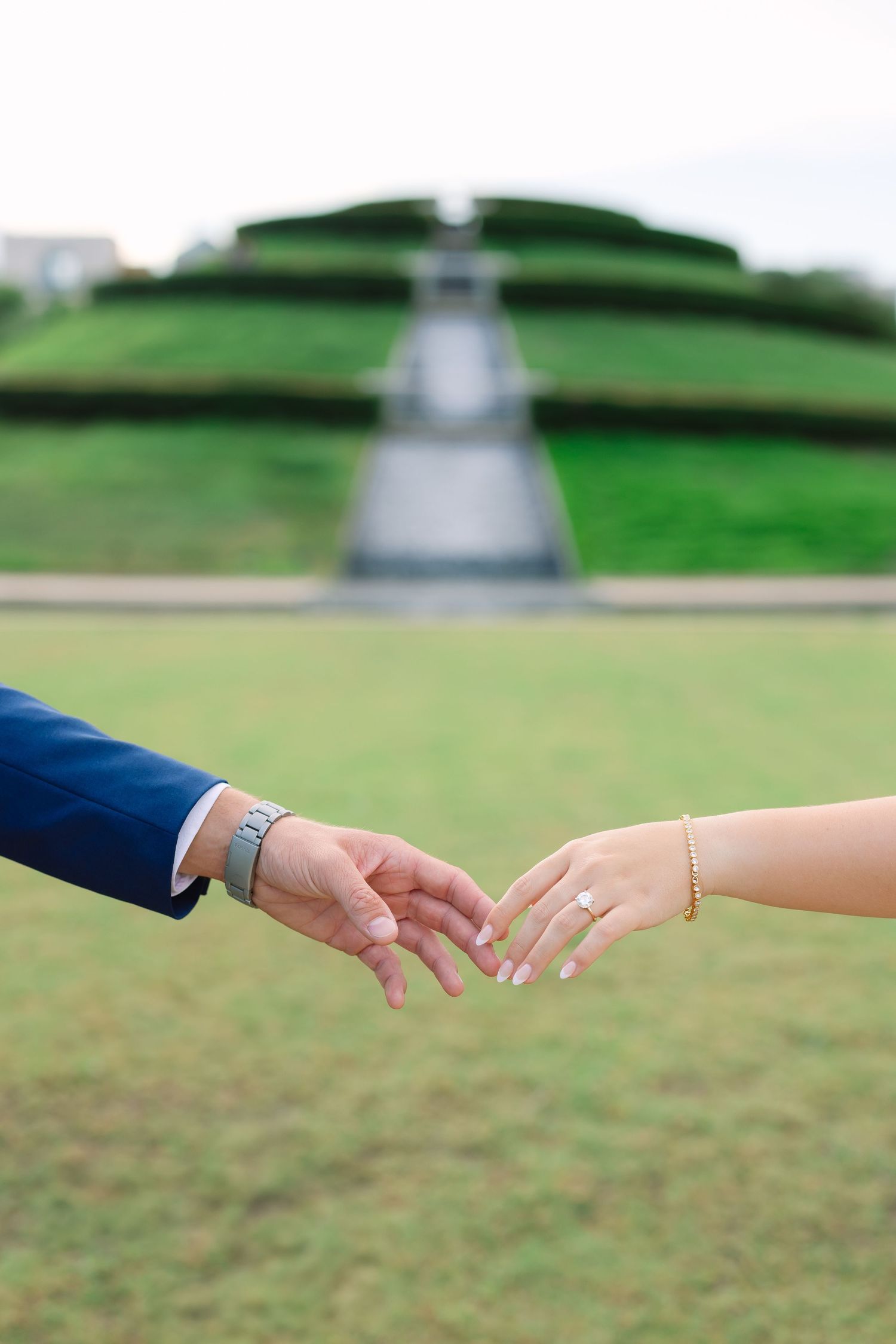 Close-up of couple's hands reaching toward each other showing wedding rings.