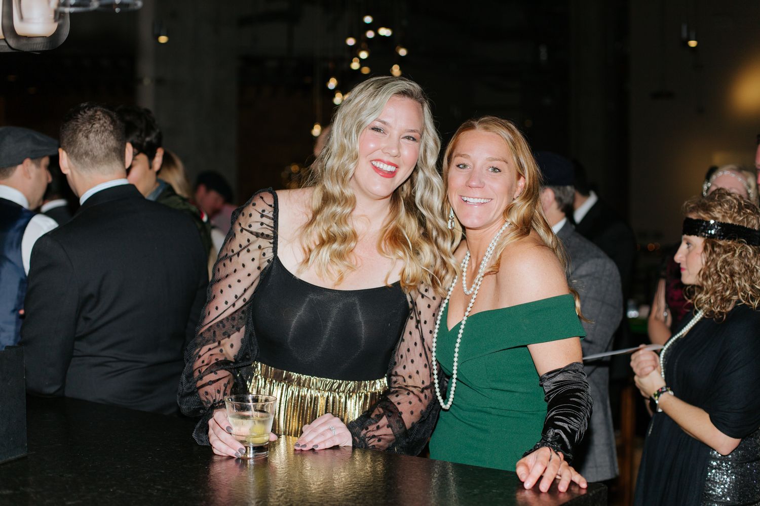 People celebrating at a formal evening event with festive decorations.