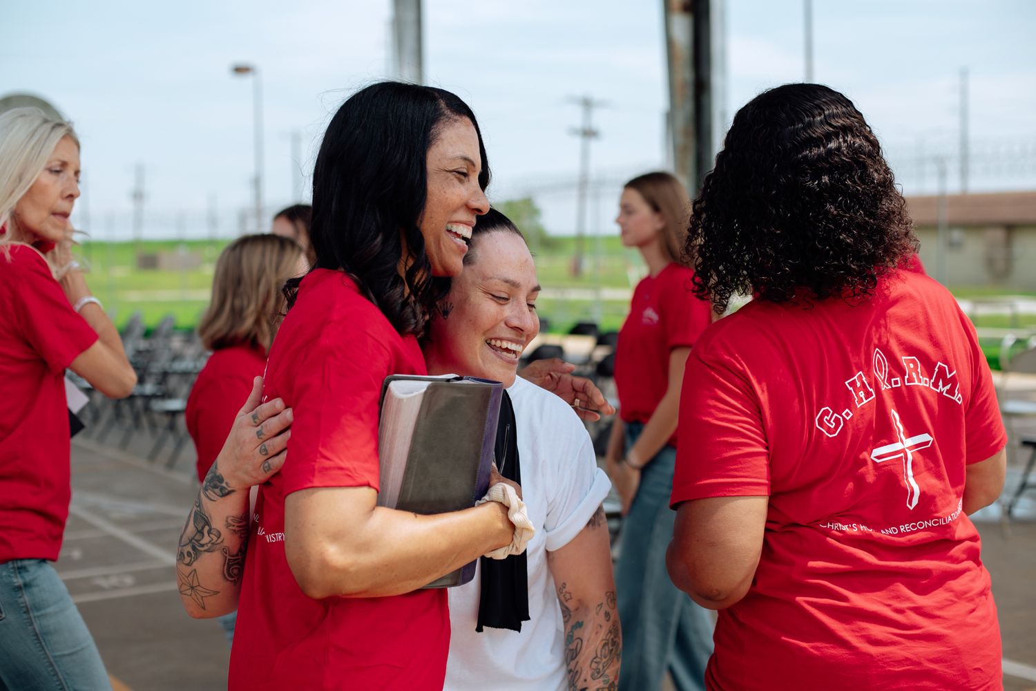 Volunteers in red shirts sharing emotional moments during a prison outreach program.