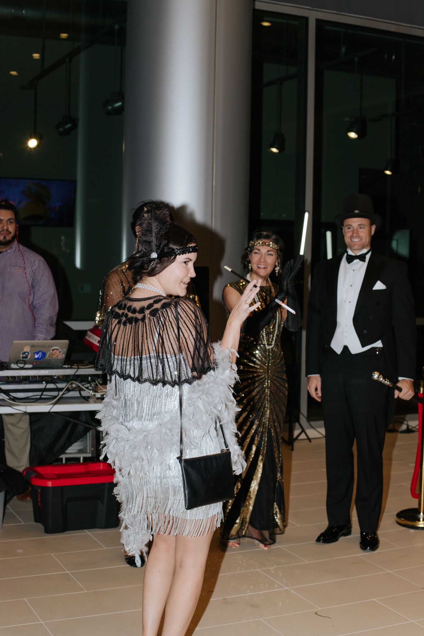 People dancing and celebrating at an indoor formal event with decorative lighting.