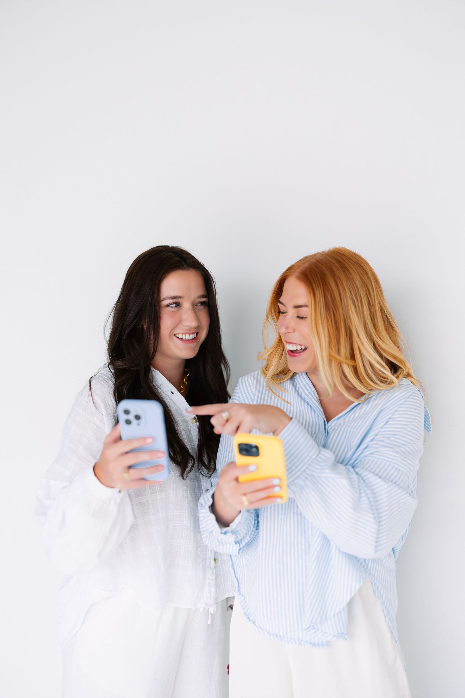 Two people sharing funny moments while looking at their phones.