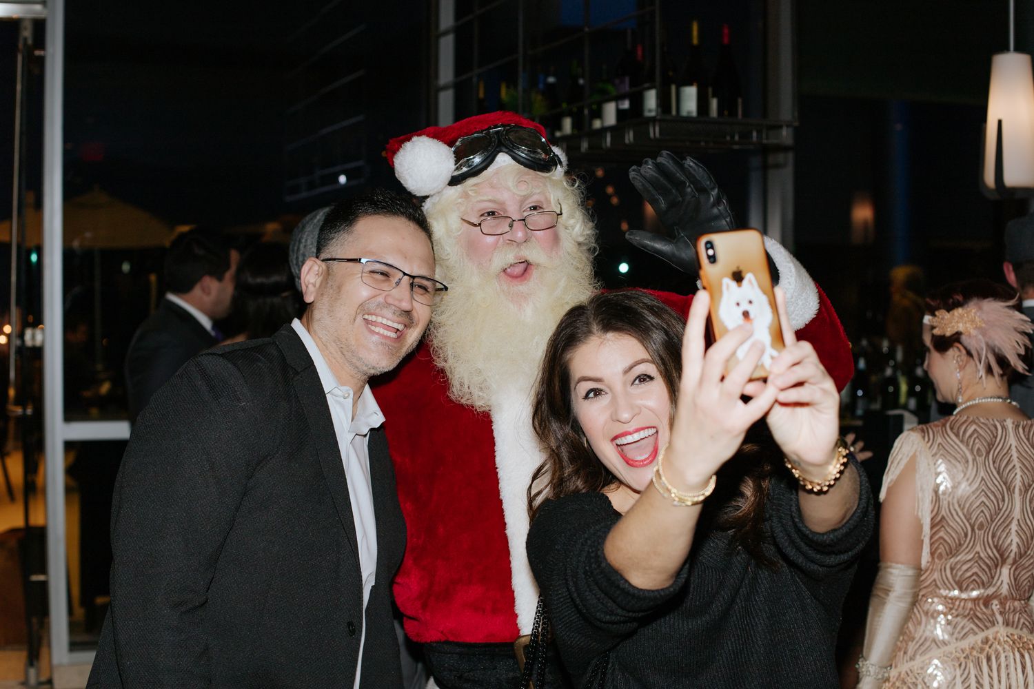 Holiday party scene with festive decorations and people celebrating indoors.