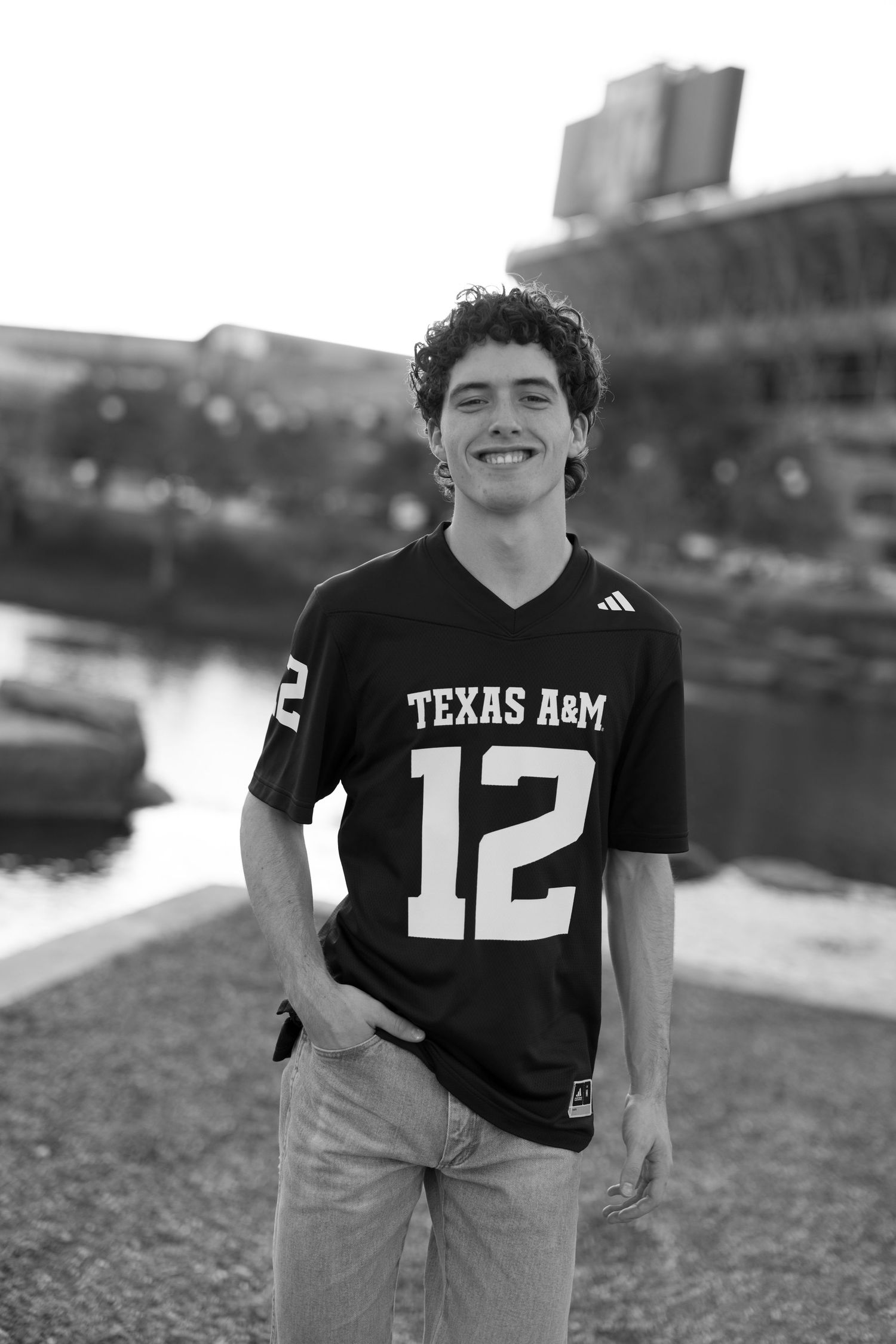 Student wearing Texas A&M jersey number 12 poses outdoors.