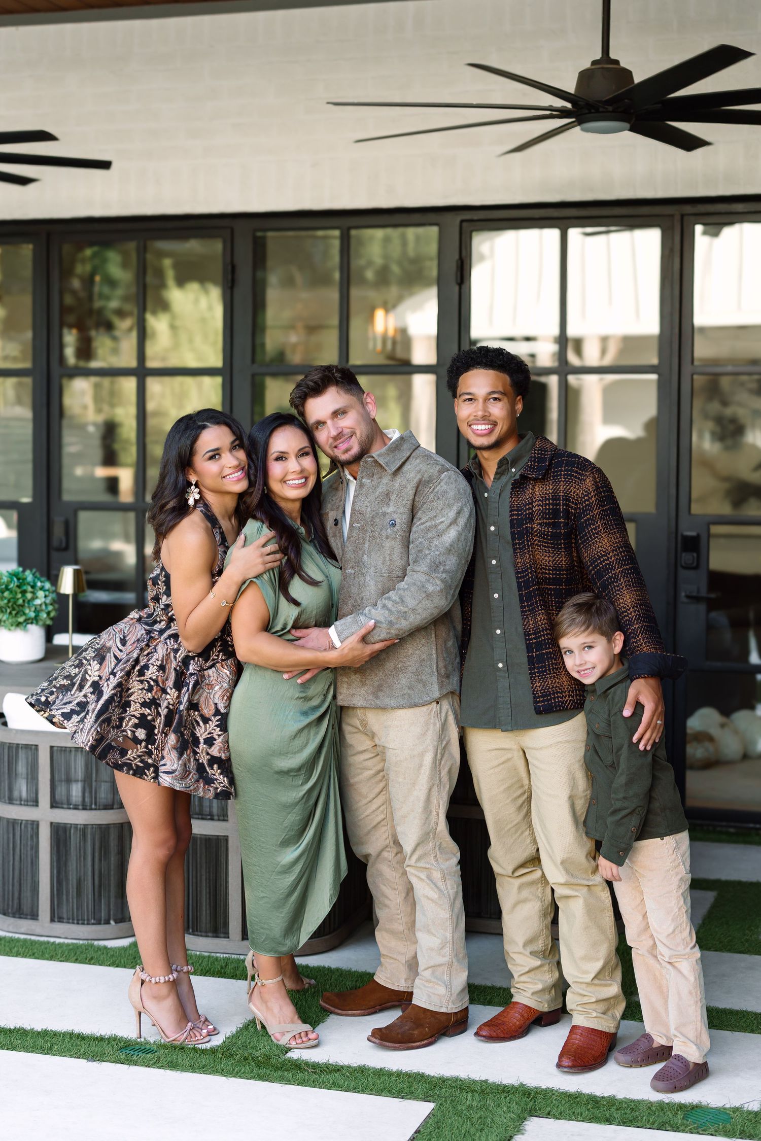 Group photo of family members embracing on outdoor porch.