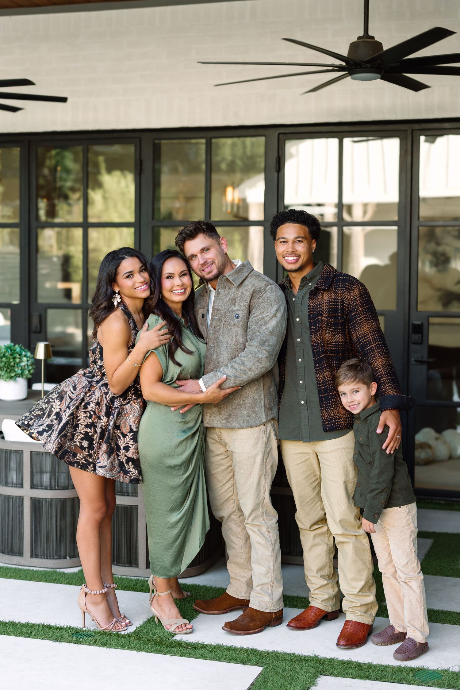 Casual group photo on a covered porch with friends in coordinating earth-tone outfits.