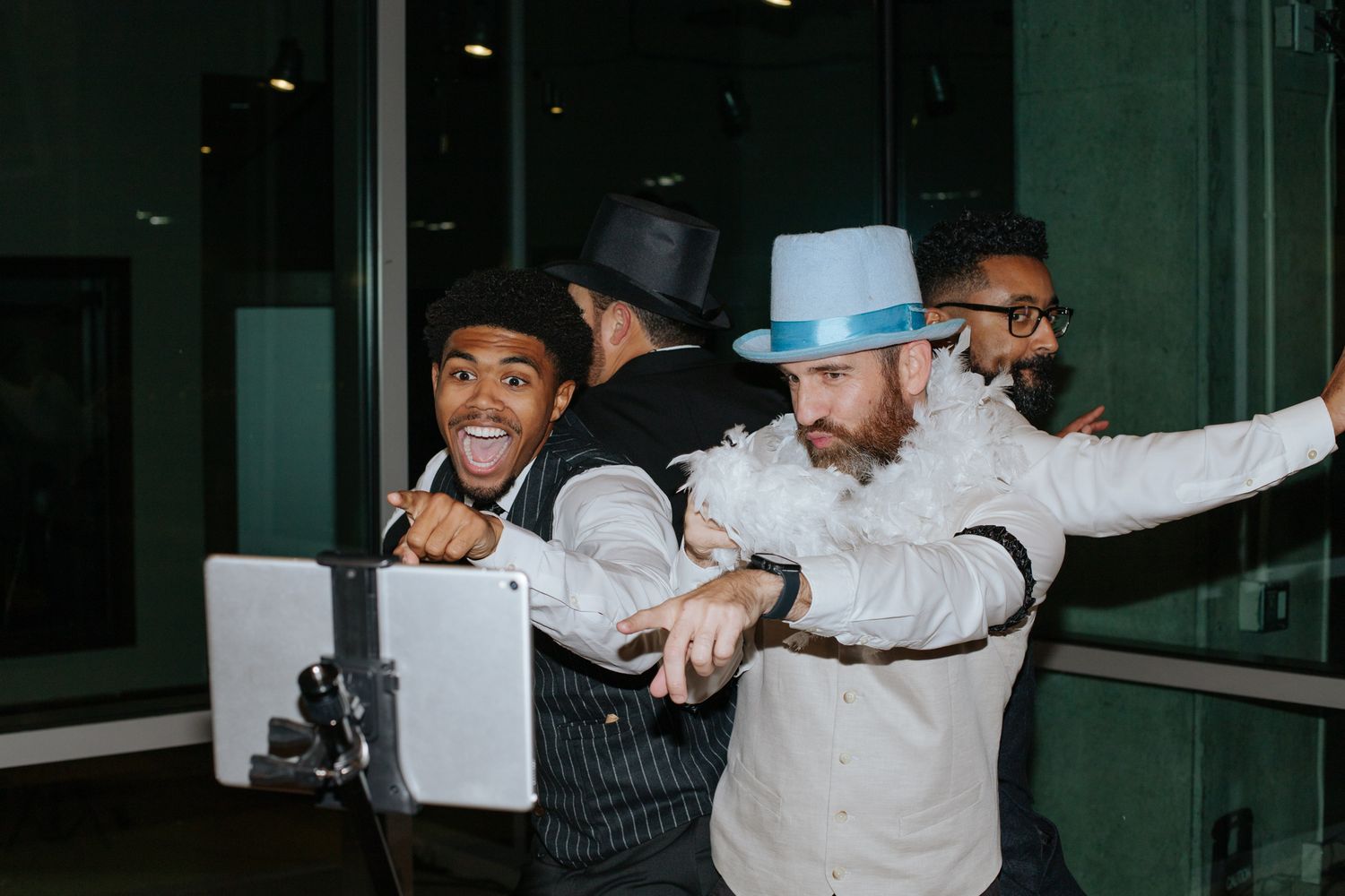 Group posing playfully in a modern indoor space with glass walls.