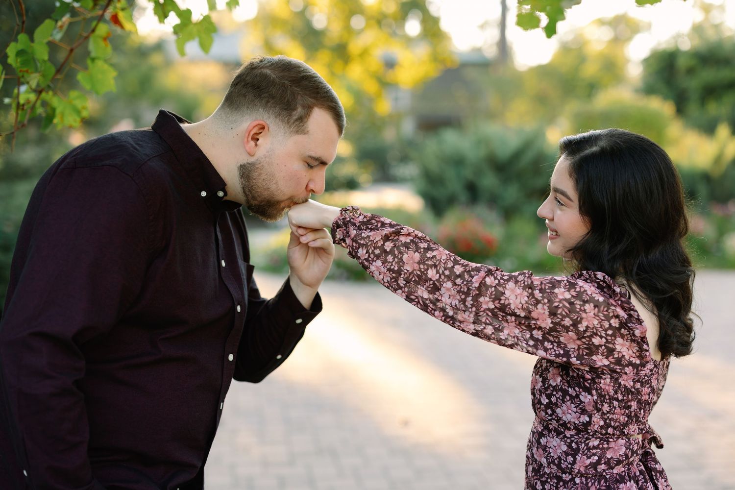 Sweet couple sharing tender moments in a blooming garden pathway.