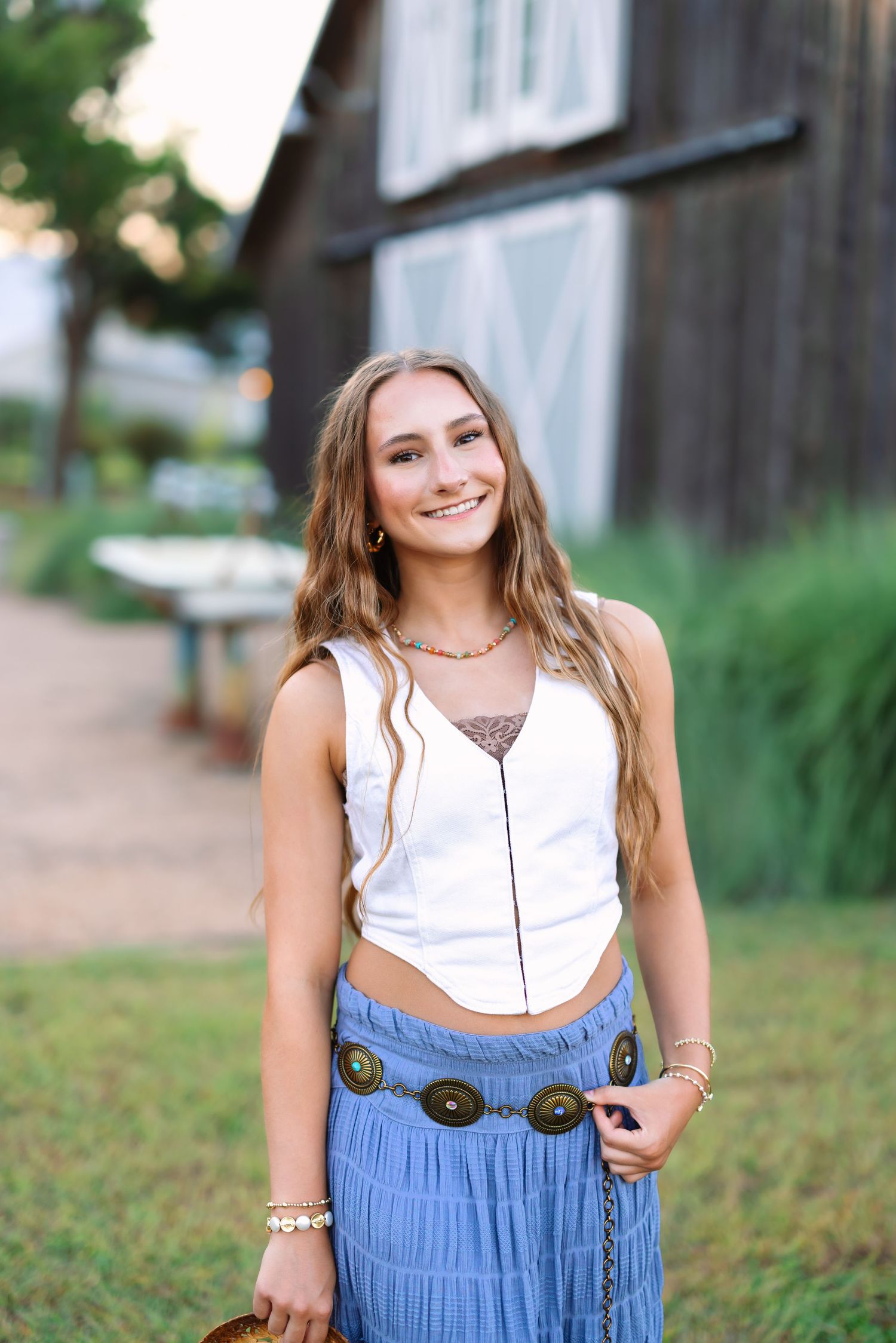 A white top and blue skirt outfit is styled for summer portraits.