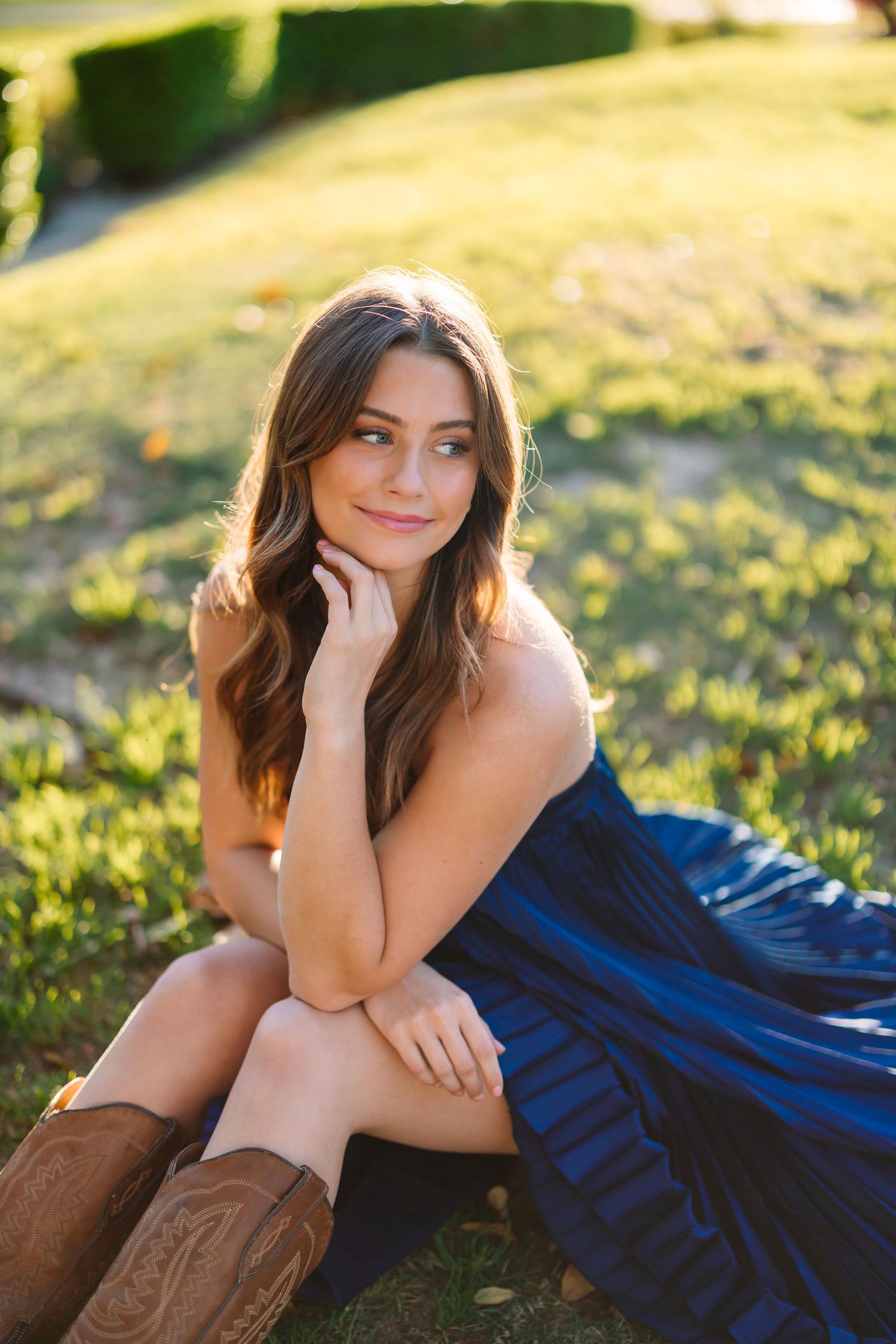 A relaxed outdoor portrait session in a grassy field during golden hour.