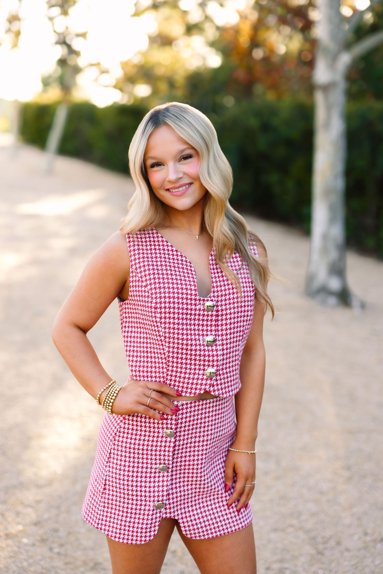A collage of four photos showing someone in a red and white gingham romper posing outdoors at sunset.