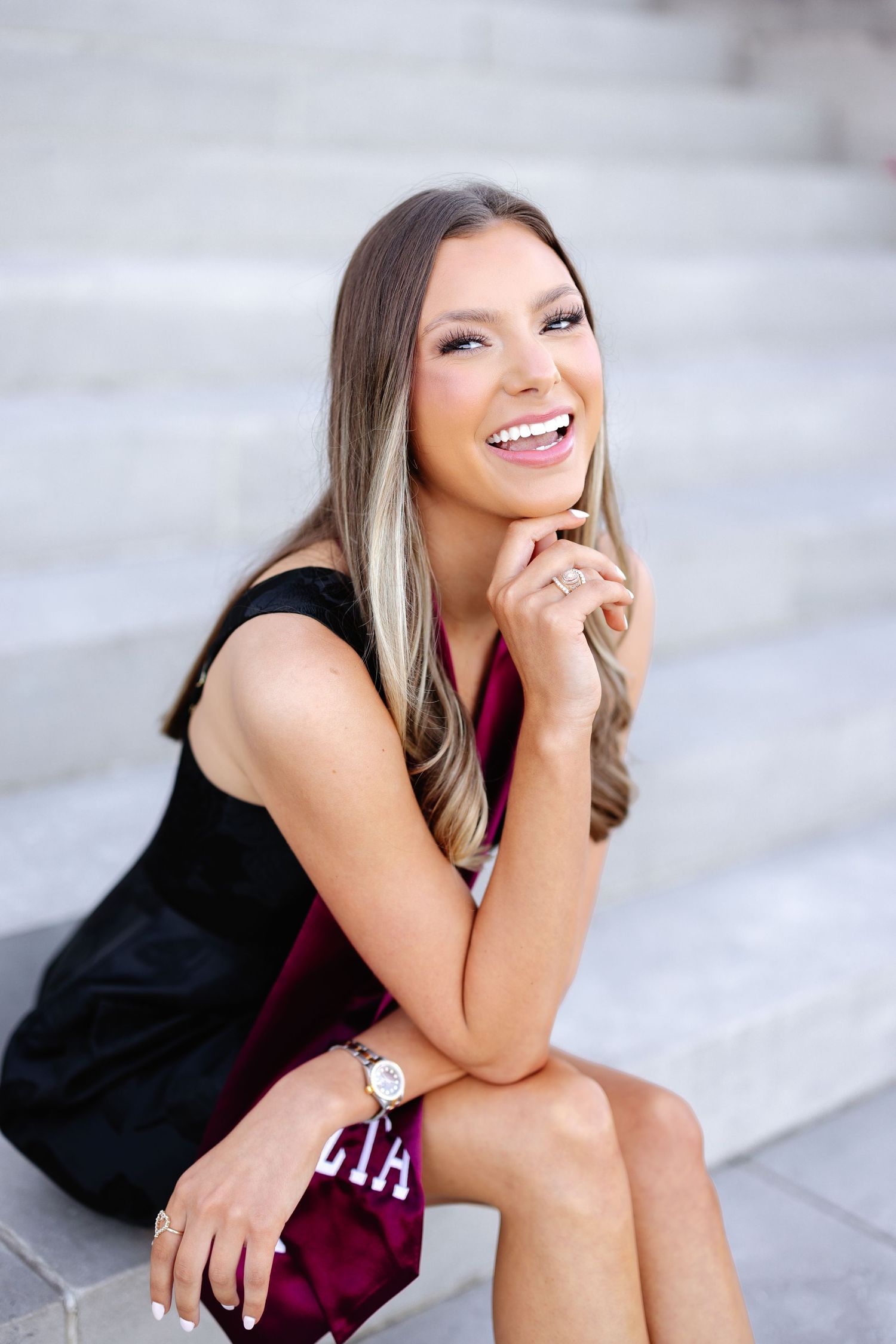 Casual portrait session on concrete steps with natural lighting.