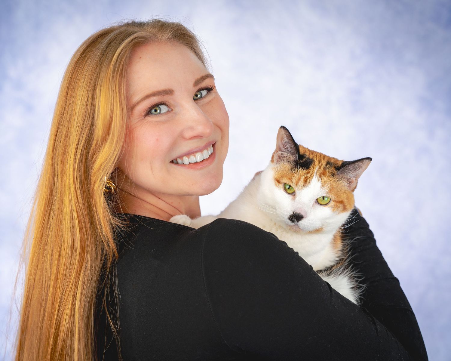A series of four connected photos showing a person with long blonde hair interacting playfully with an orange and white cat.