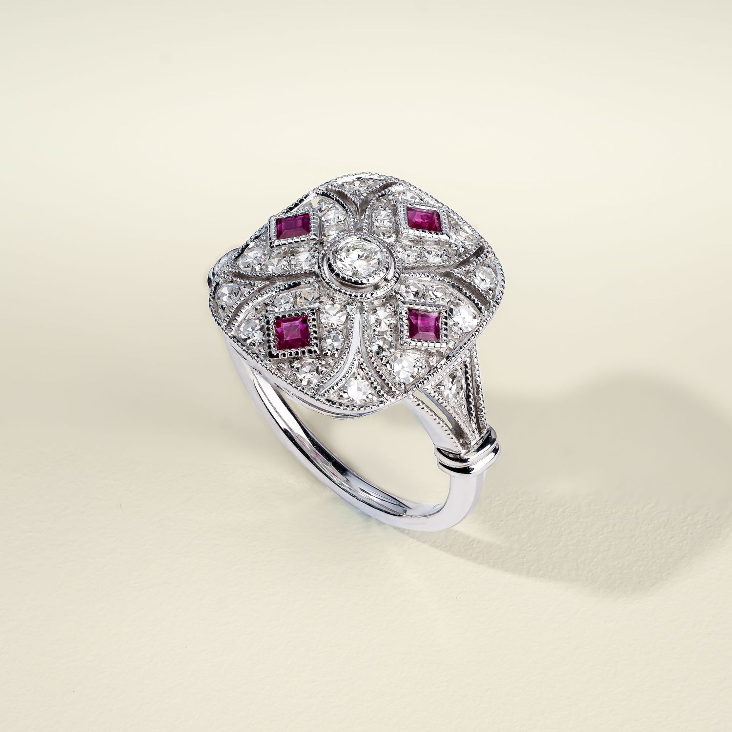 Art deco inspired white gold ring with pink rubies and diamond accents shown in multiple views.