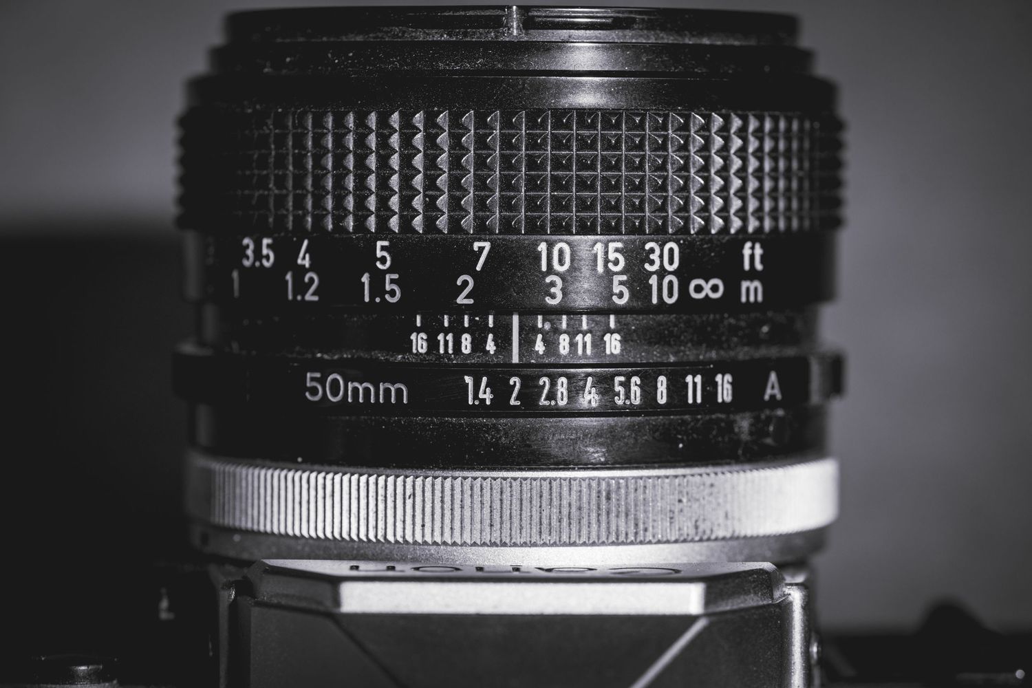 Close-up details of vintage camera lens aperture rings and focus markings showing manual control settings.