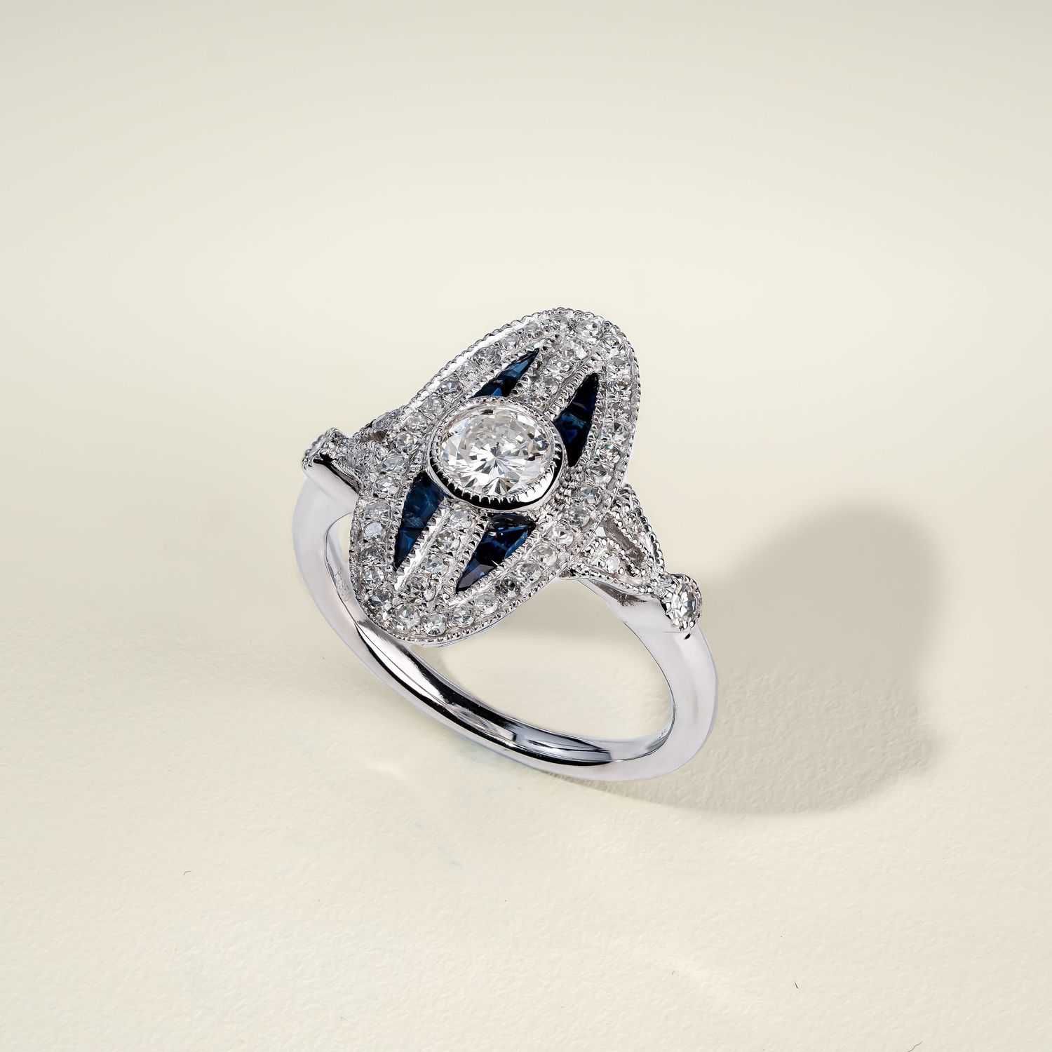 Modern white gold engagement ring with center diamond and geometric side details.