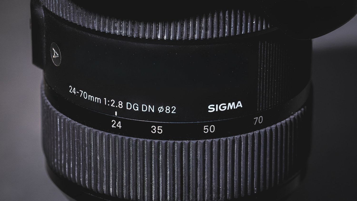 Close-up view of a Sigma 24-70mm f/2.8 DG DN camera lens showing the focal length markings and branding.