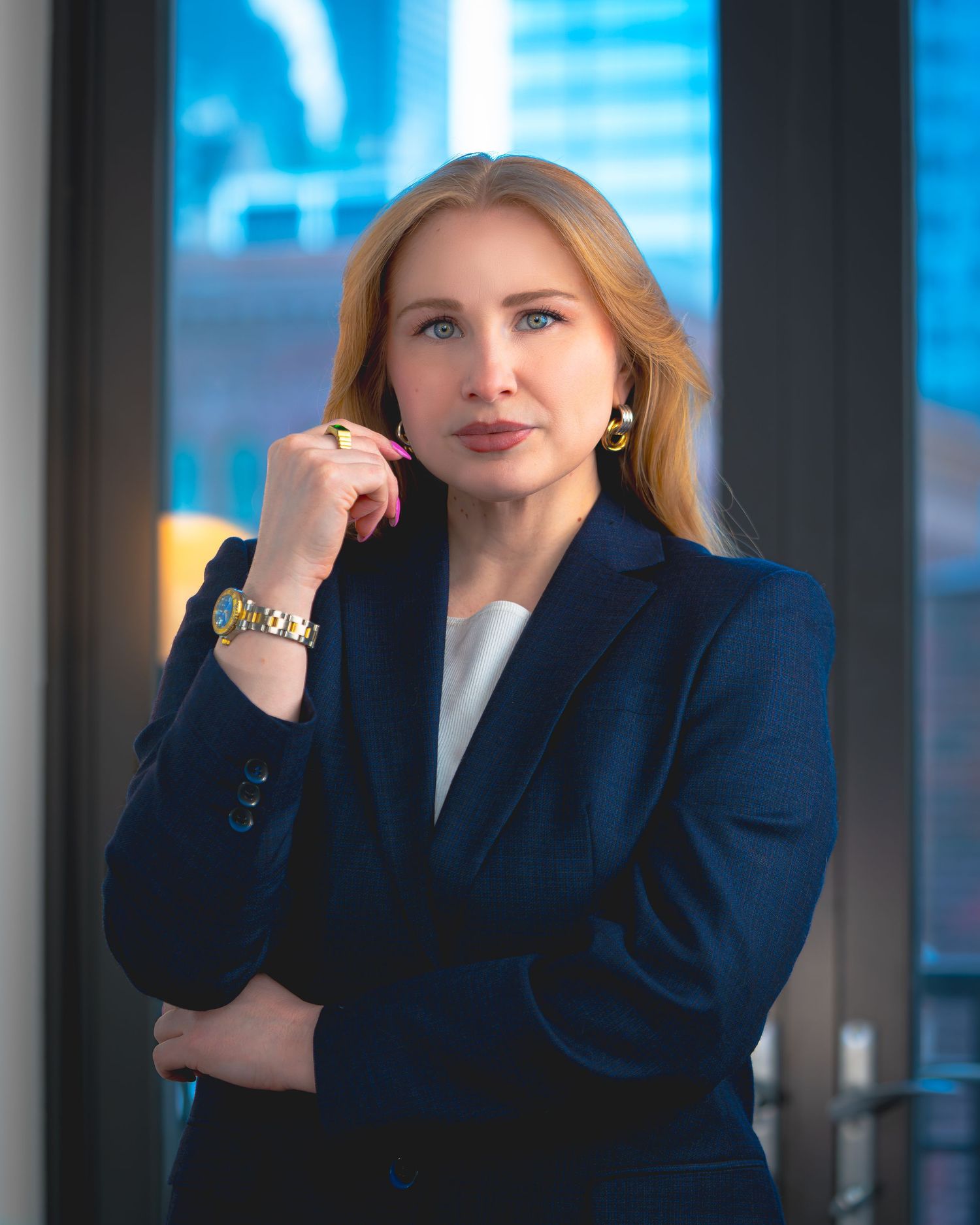 Professional in a navy blazer poses thoughtfully against a blue-tinted office background in a series of expressions.