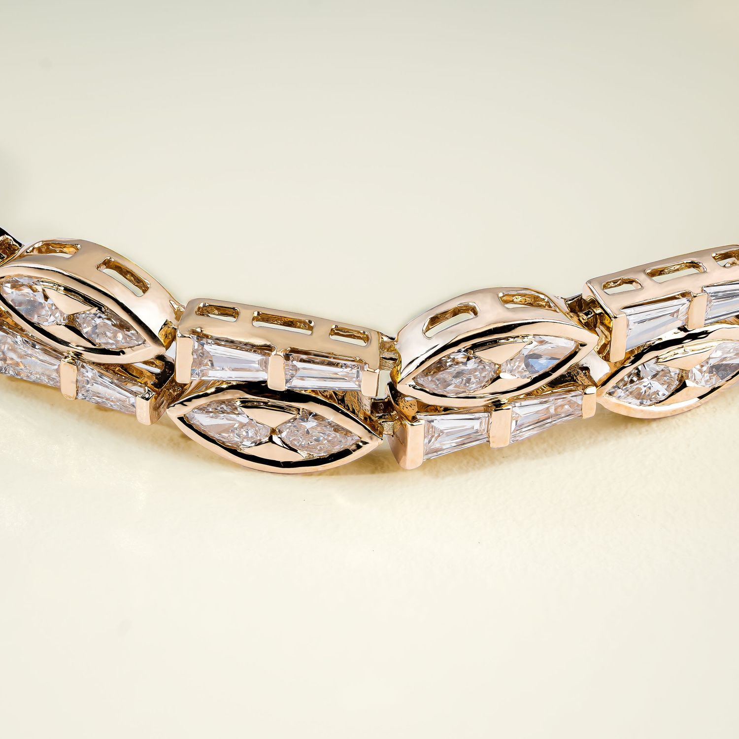 Elegant gold bracelet with twisted design featuring alternating baguette and round diamonds.