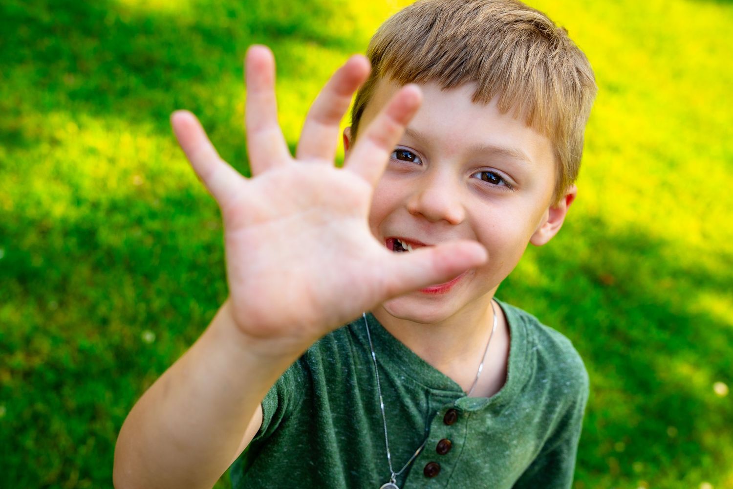 A sequence of photos showing a child holding up fingers to count from one to five against a bright green background.