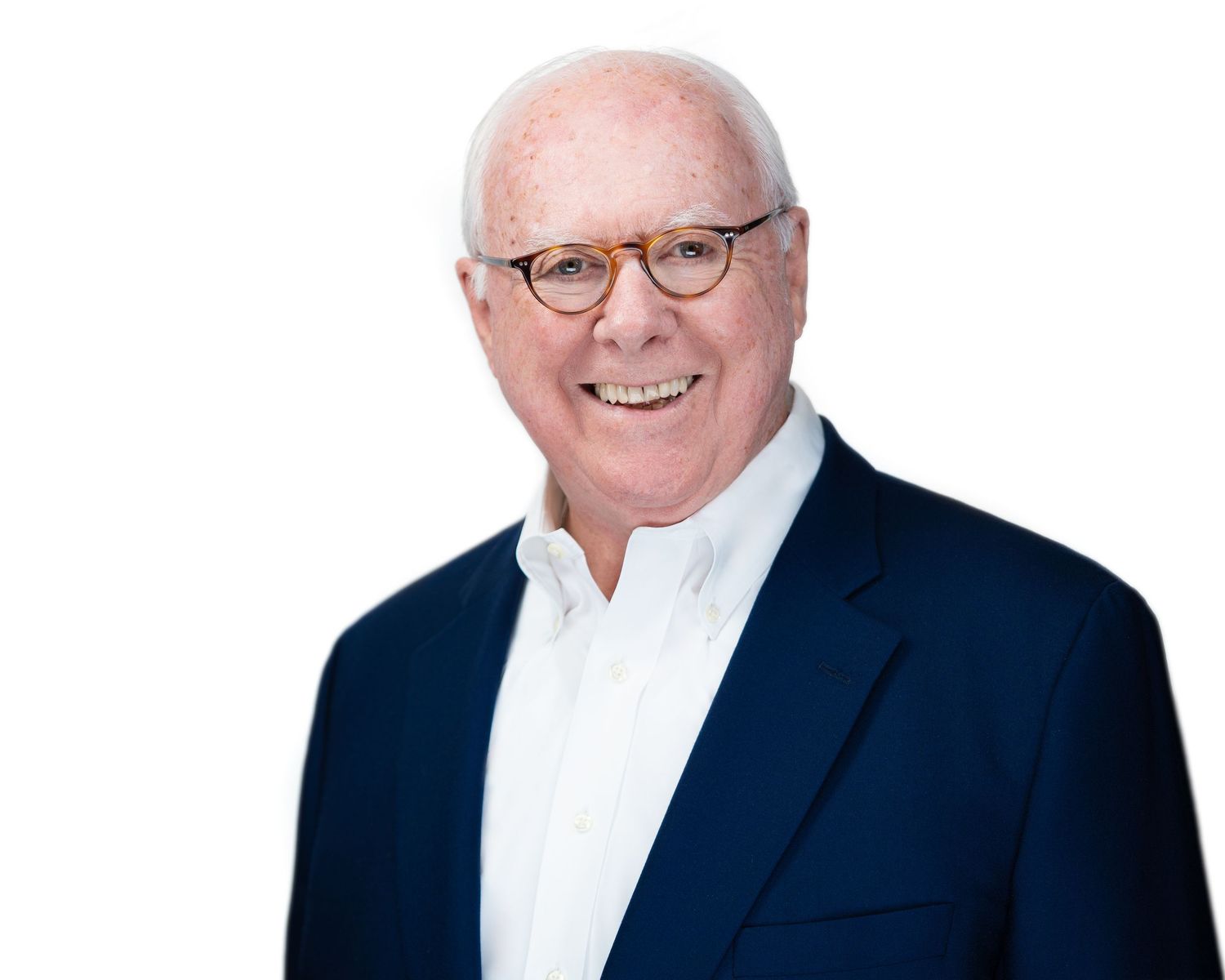 Professional corporate headshot of person in dark suit with glasses.