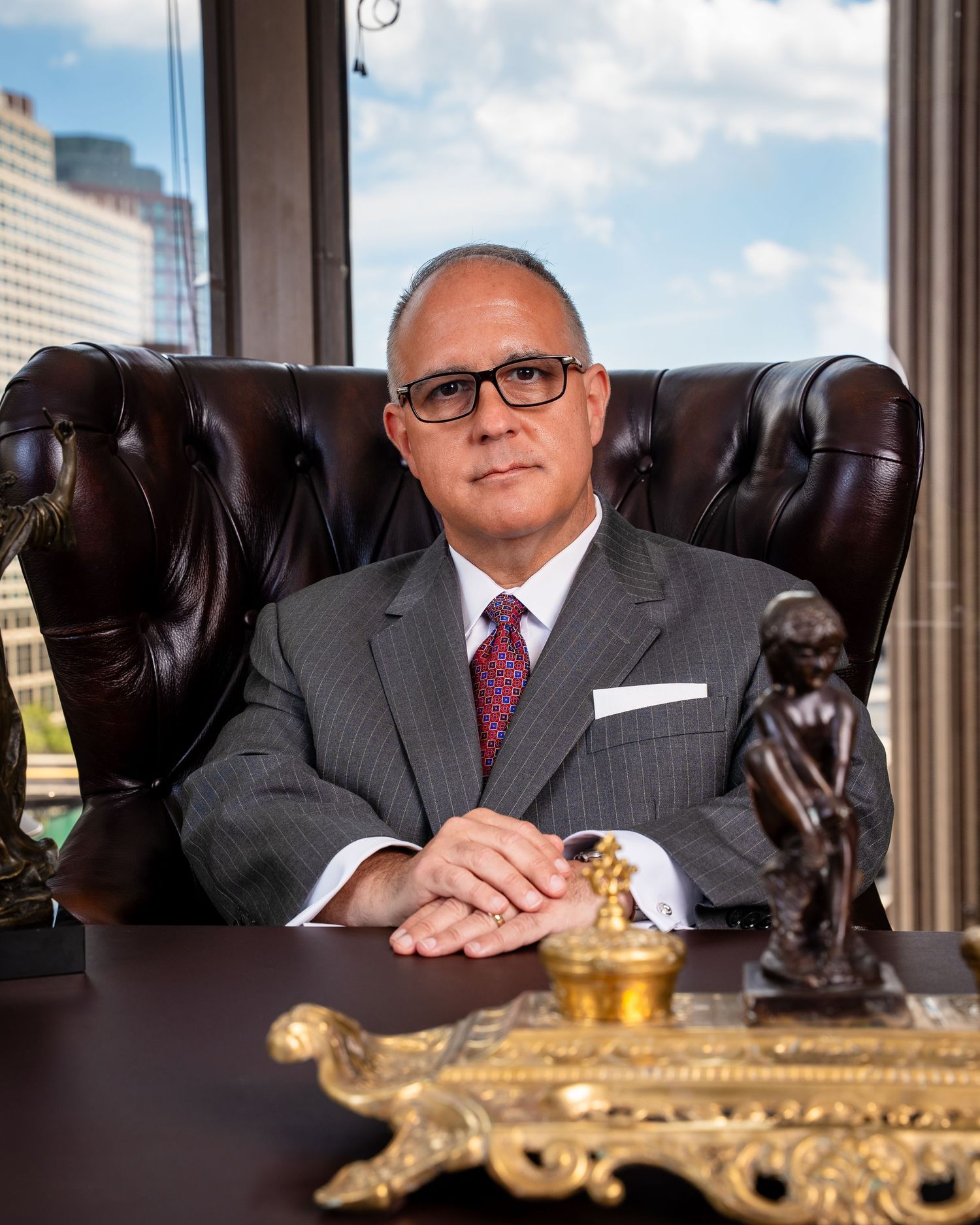 Professional office with leather chair and decorative gold accents against city backdrop.