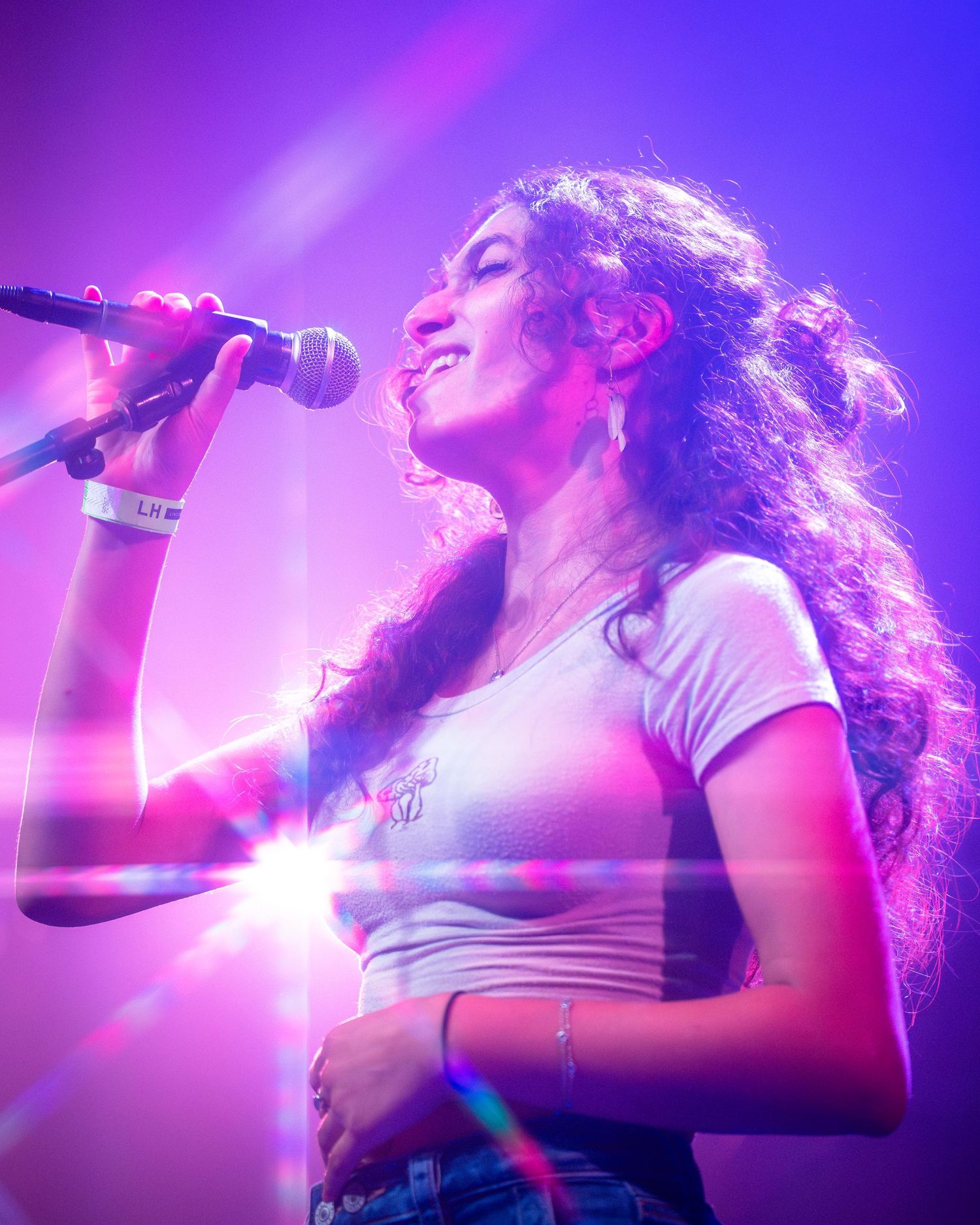 Concert performance lit with purple and pink stage lights creating a dreamy atmosphere.
