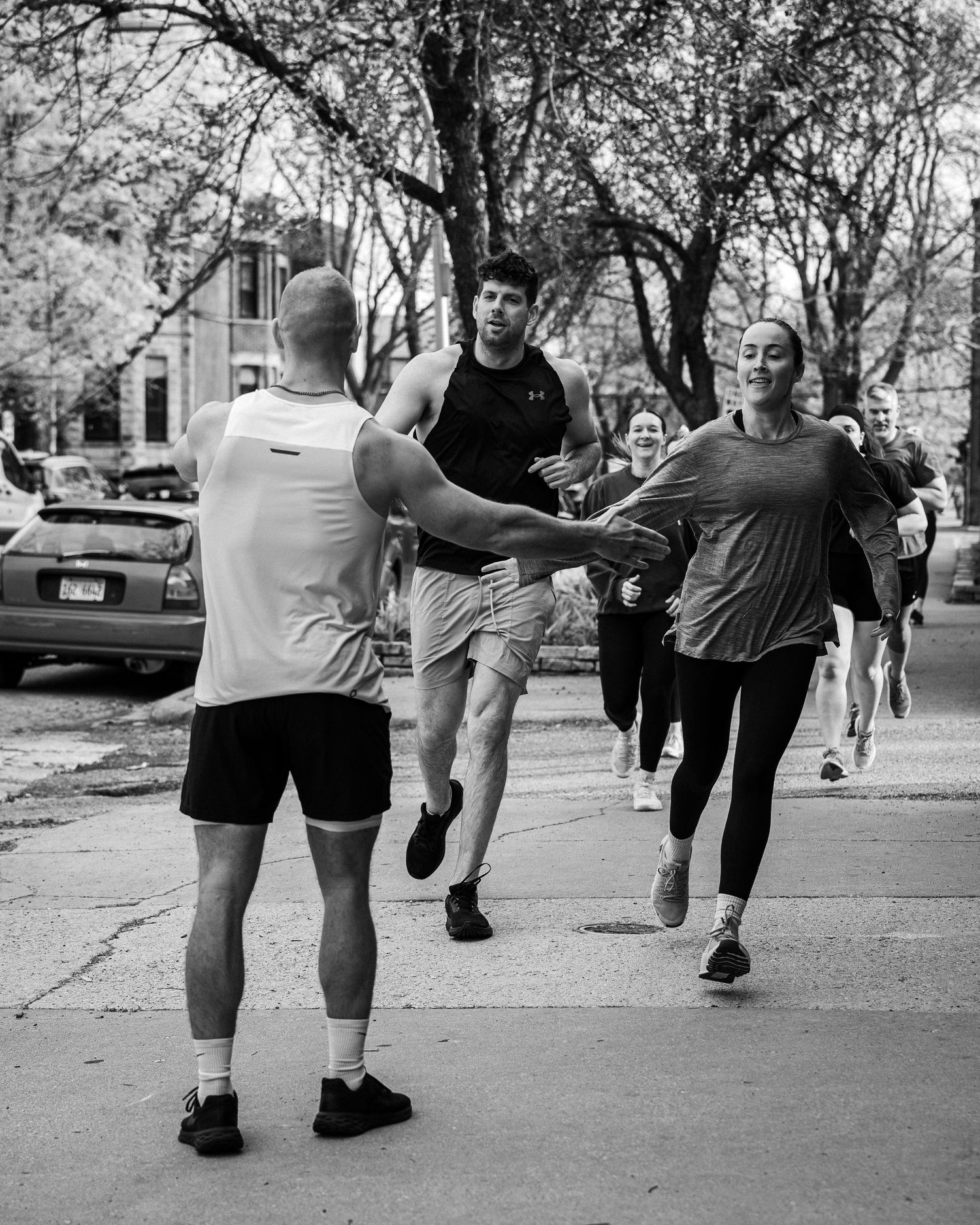 Black and white photo of people exercising in a park.
