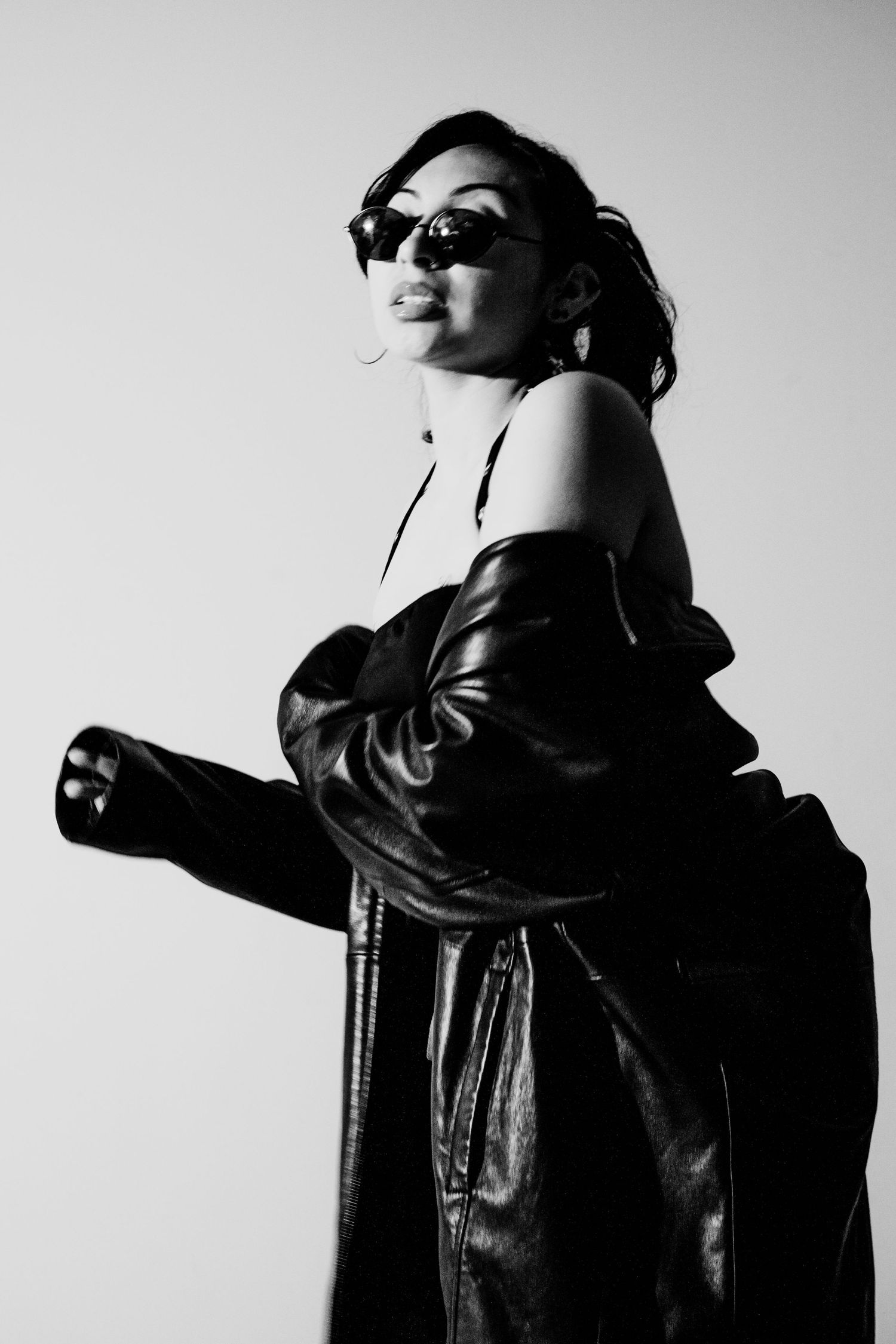 Dramatic black and white portraits featuring leather jacket and sunglasses with bold poses.