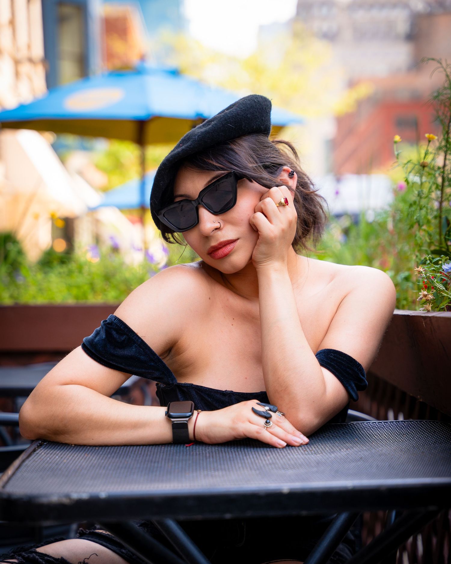 Artistic portrait series of person in black lounging outdoors with sunglasses.