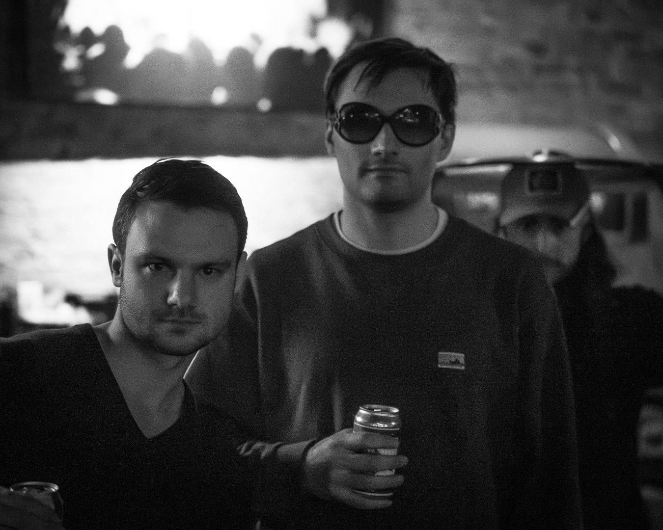 Black and white portrait of group in casual attire holding drinks.