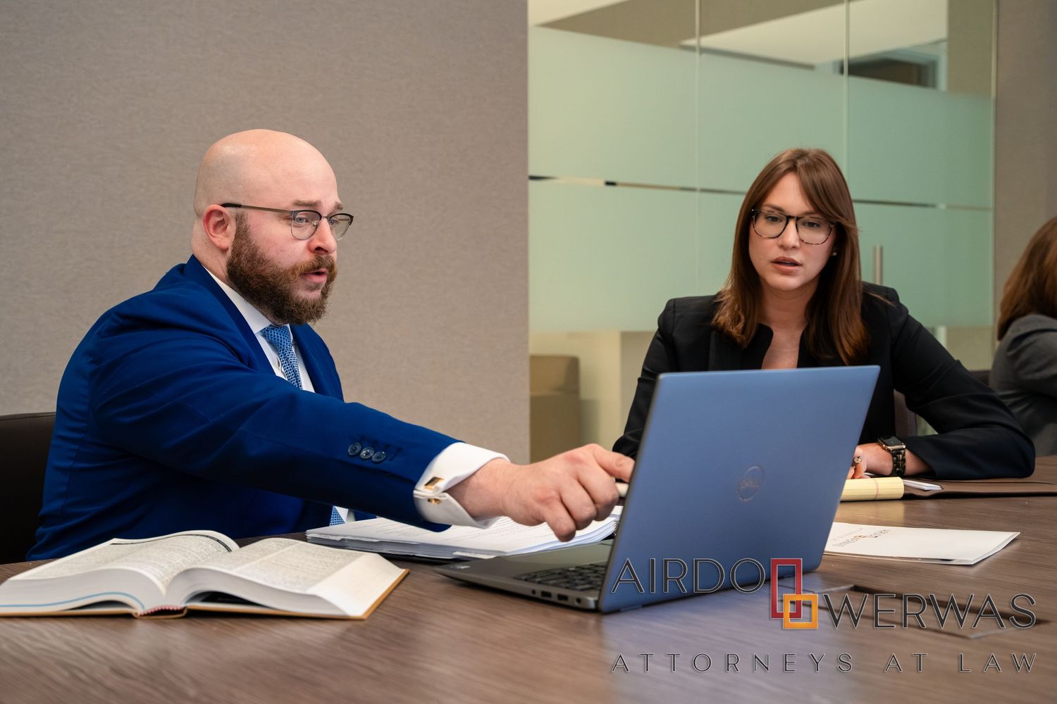 Legal professionals reviewing documents at conference table.