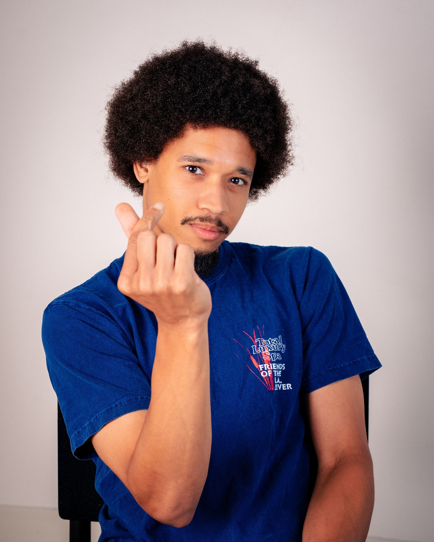 Person in blue t-shirt displaying range of expressions against white backdrop.
