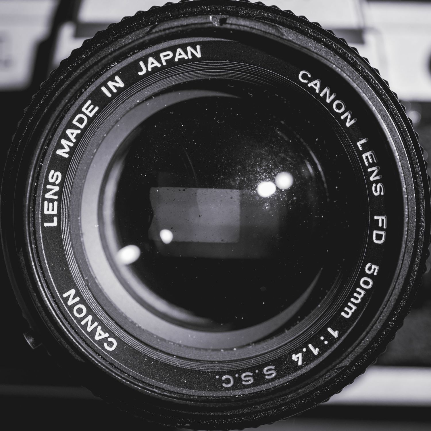 Close-up macro shots of vintage camera lens elements showing Japan text and aperture markings in black and white.