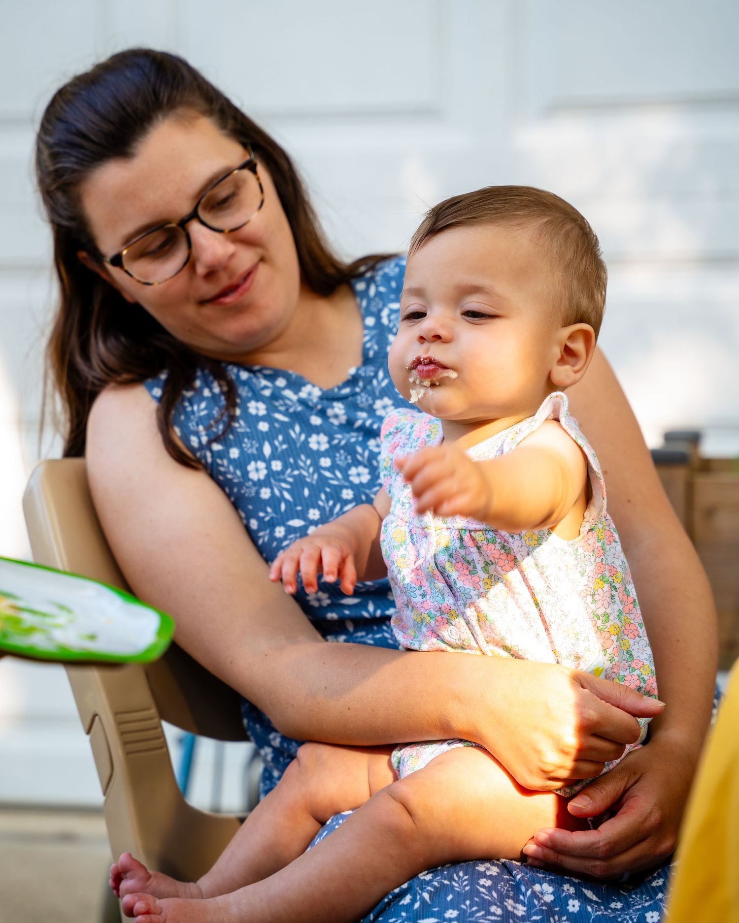 A series of candid moments showing a baby and caregiver in a blue polka dot dress sharing playful interactions.