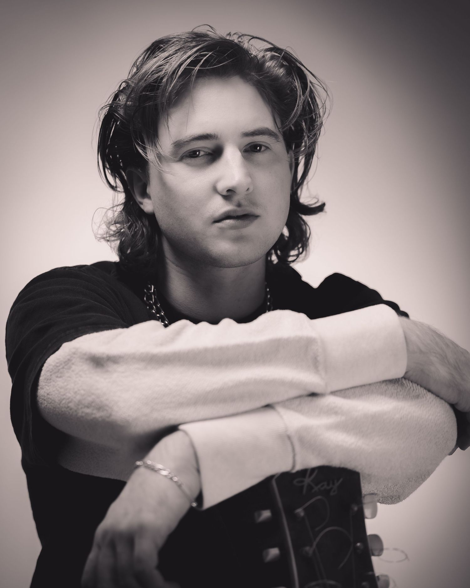 Monochrome series showing musician in relaxed poses with head resting on arms.