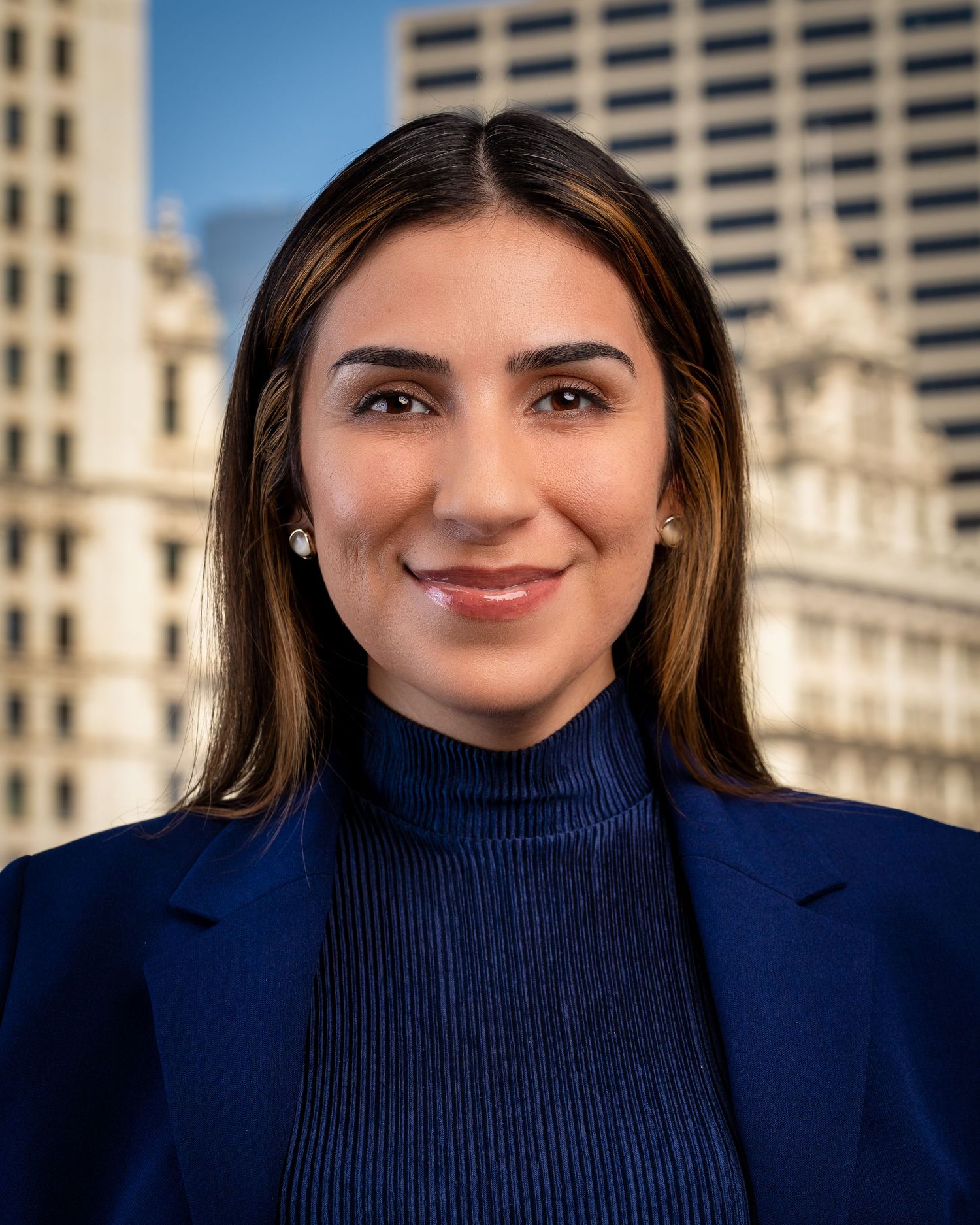 Business portraits featuring navy turtleneck against modern architectural background.