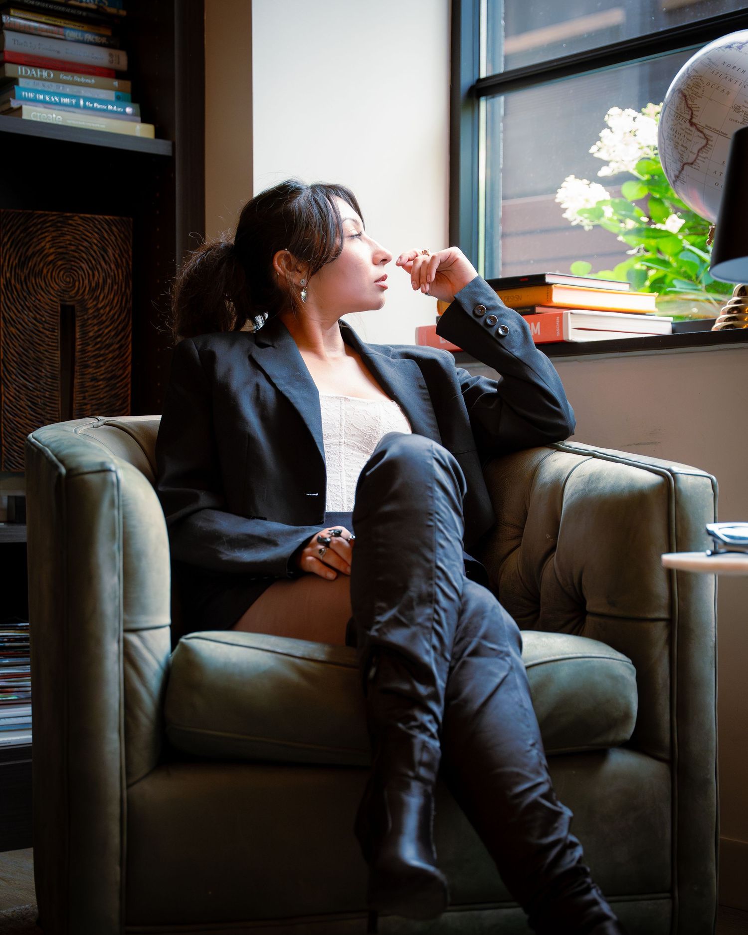 Elegant portrait by window with black blazer and natural lighting.