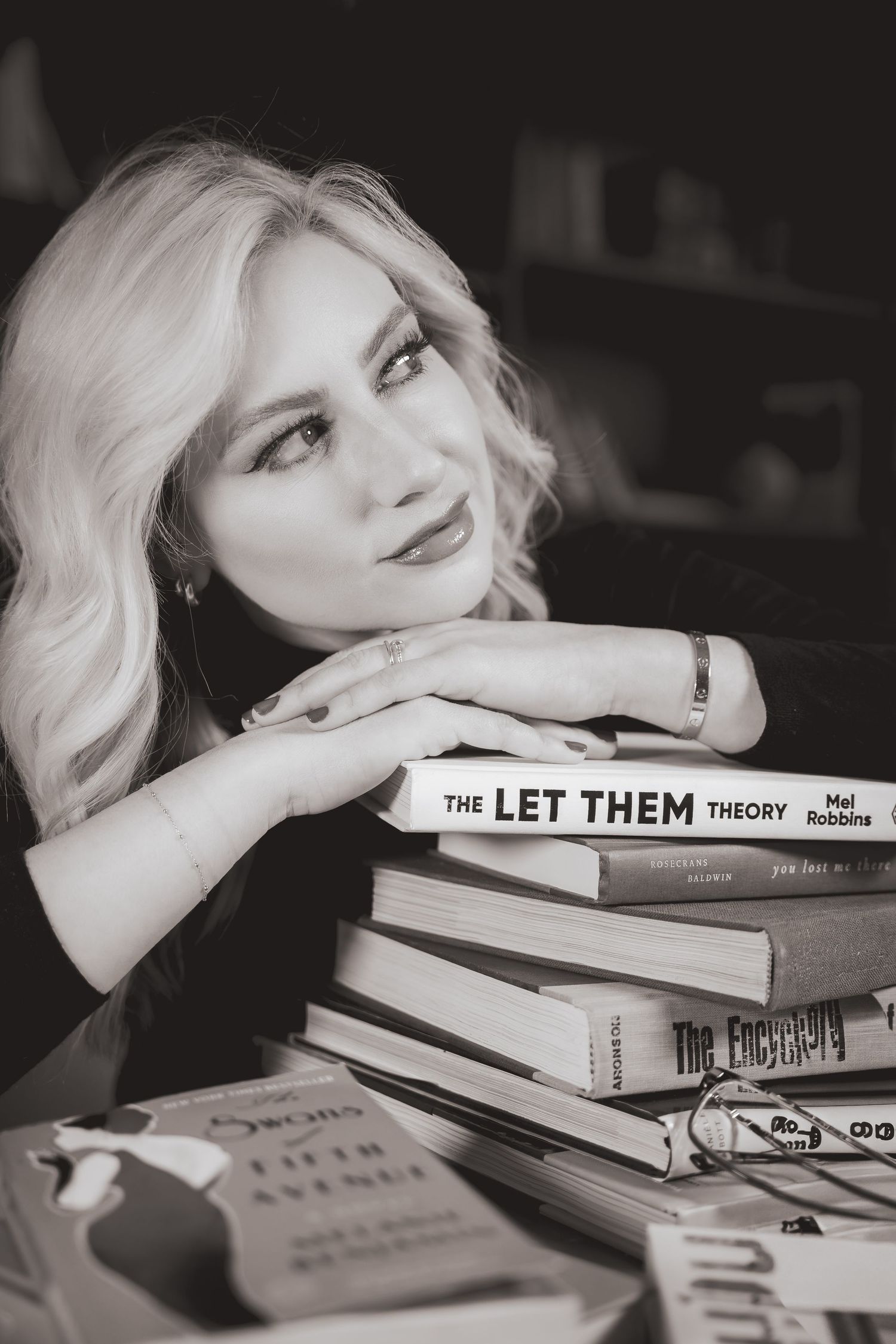 Black and white portraits showing someone resting their head on stacked books with titles visible.