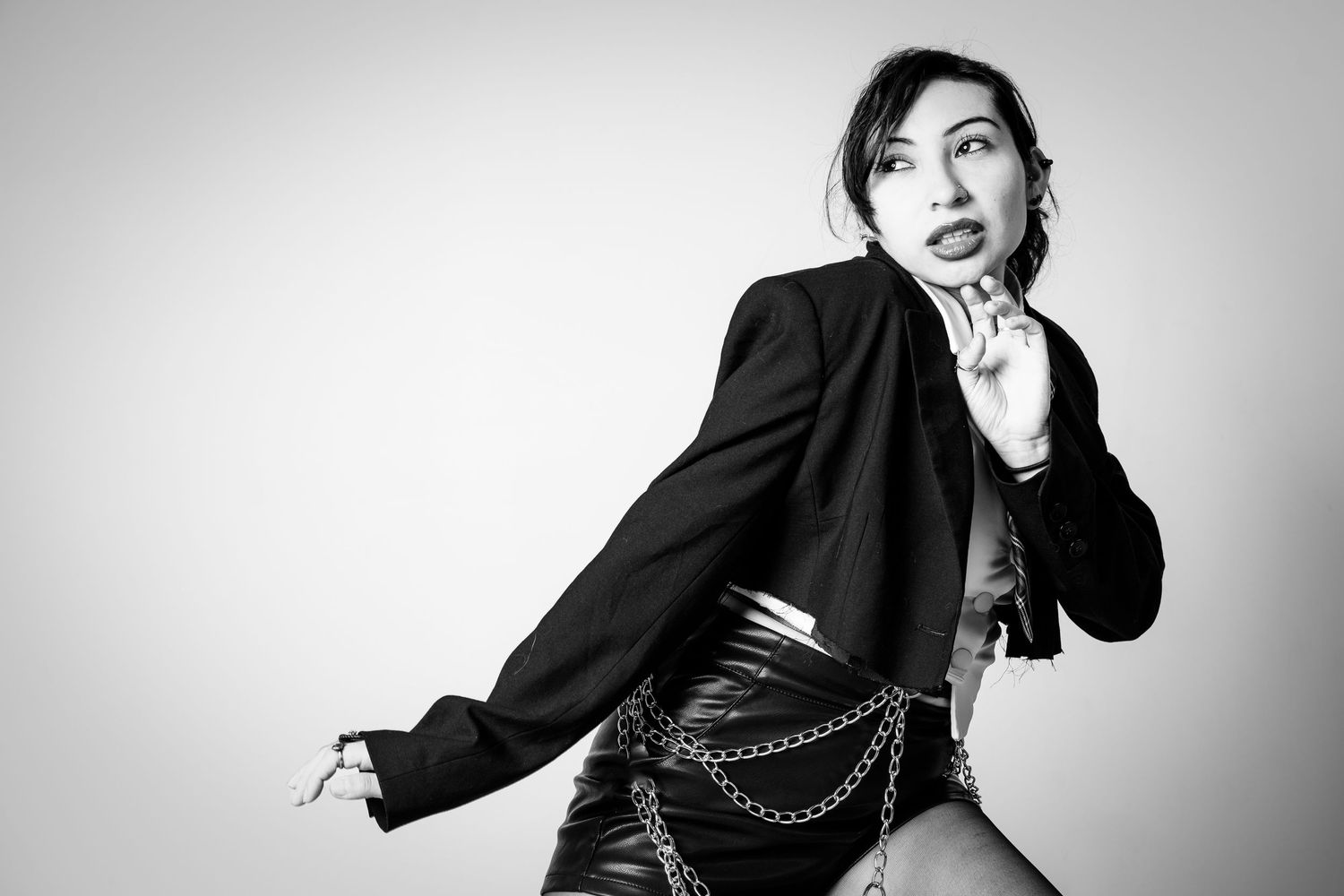 Artistic black and white fashion portraits showing dynamic poses against light background.
