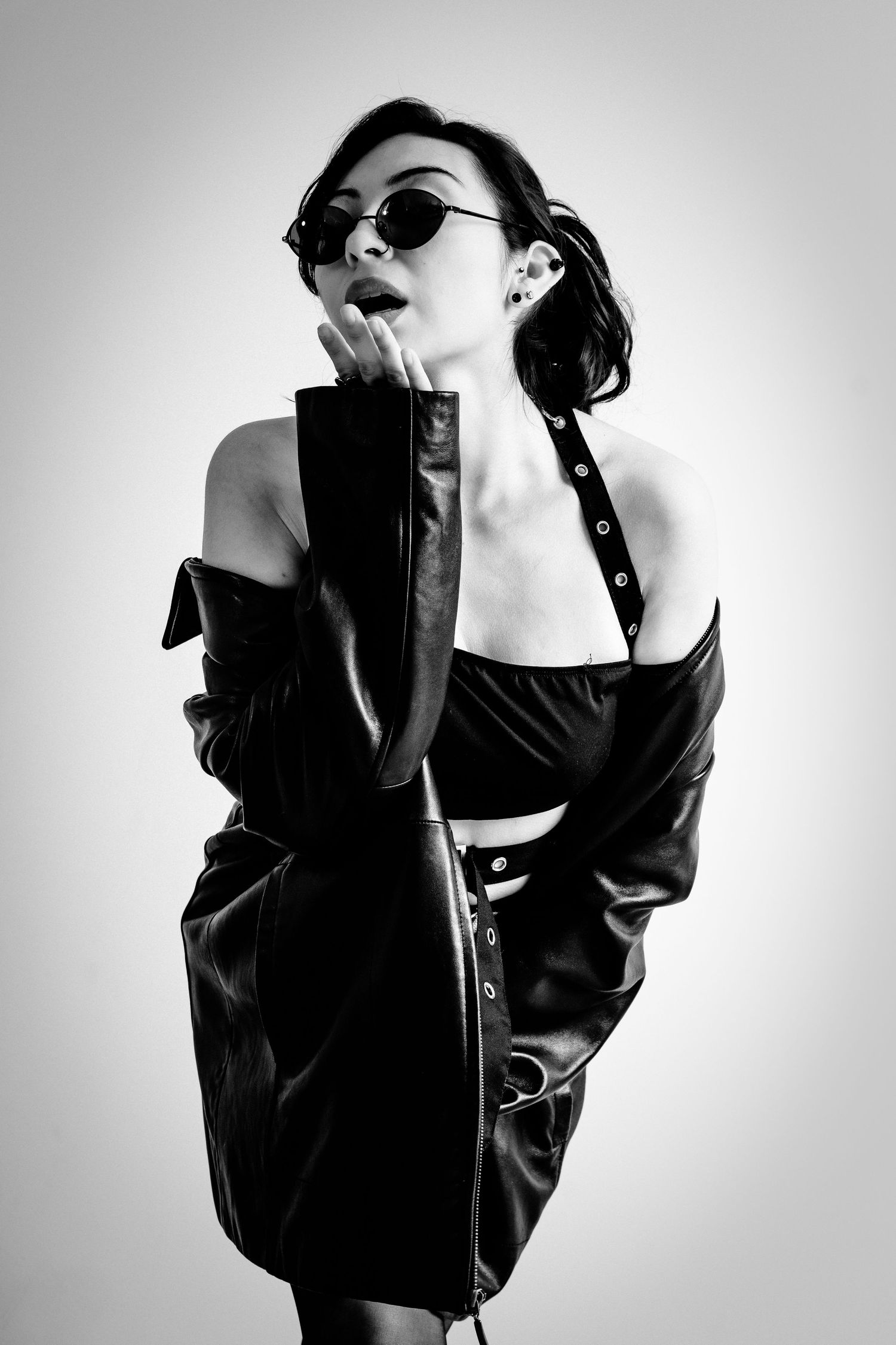 Artistic black and white fashion portrait with sunglasses and leather jacket.
