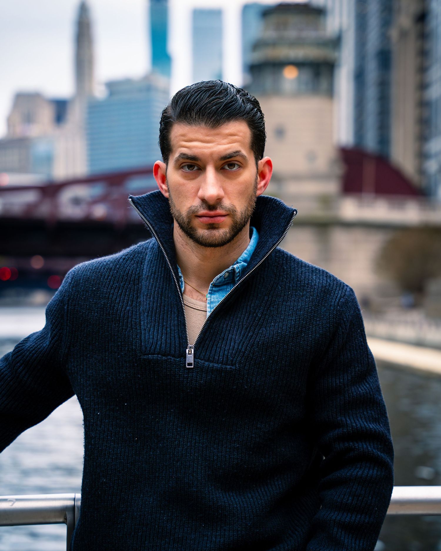 Professional portrait series showing a man in a navy sweater against an urban backdrop.