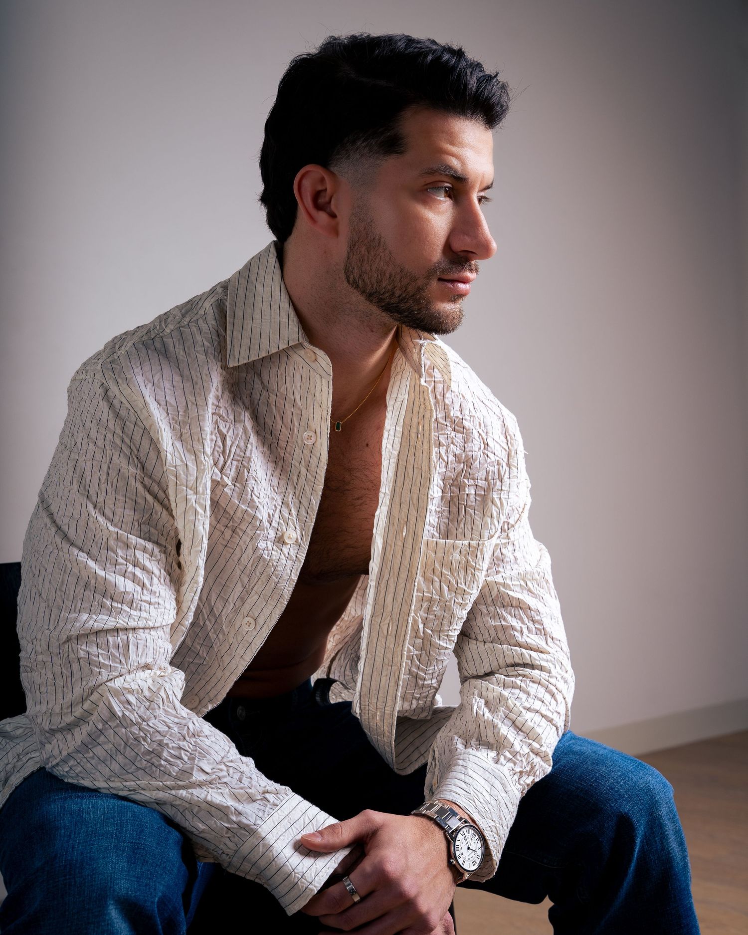 Contemplative poses in cream knit jacket against neutral studio background.